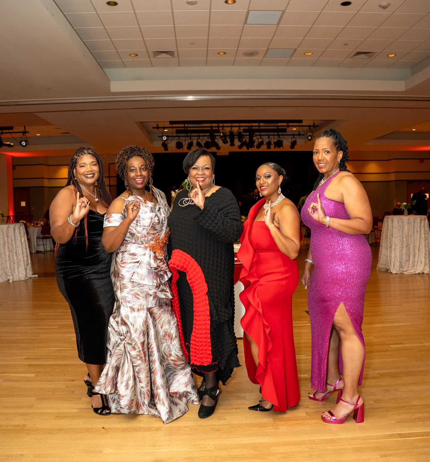 Guests in formal attire enjoying a social gathering in an elegant ballroom setting.