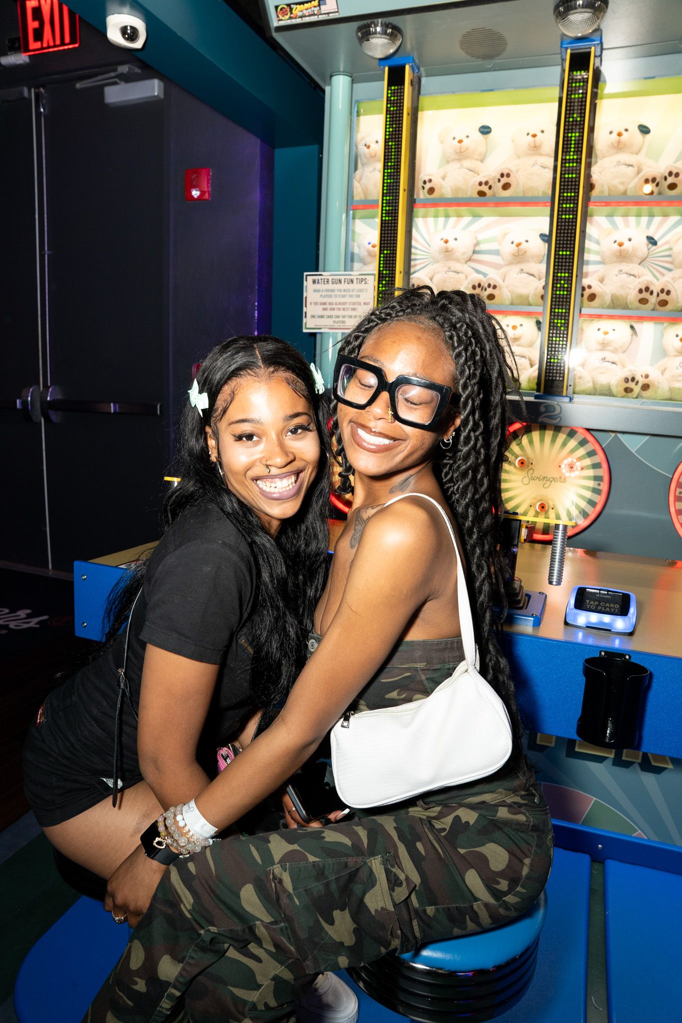Friends enjoying a fun night out at an arcade with playful poses and laughter.