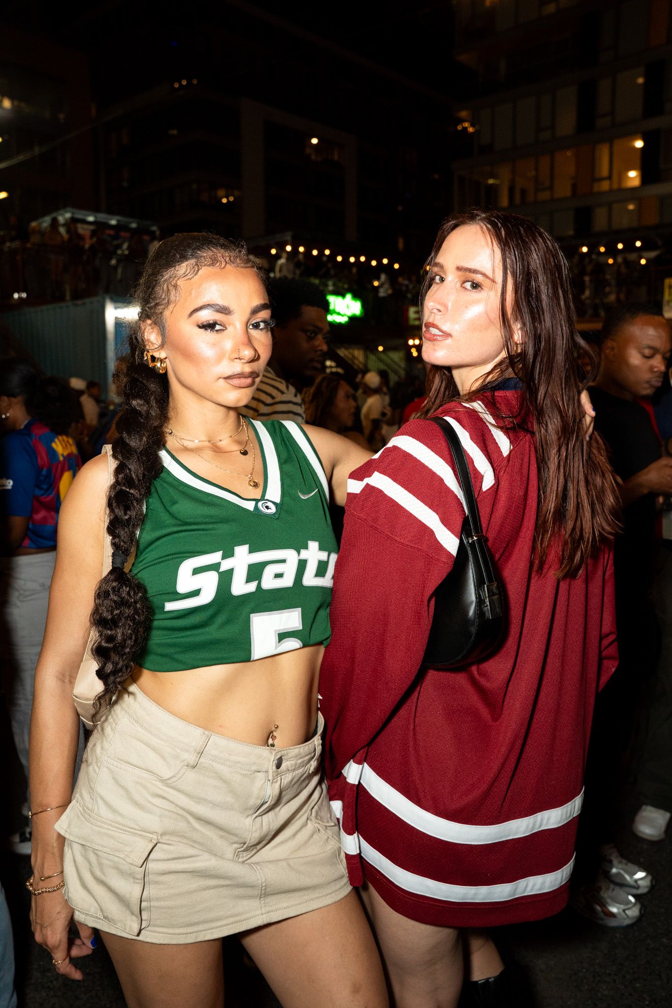 Party scene with people wearing sports-themed crop tops and casual attire at a night event.