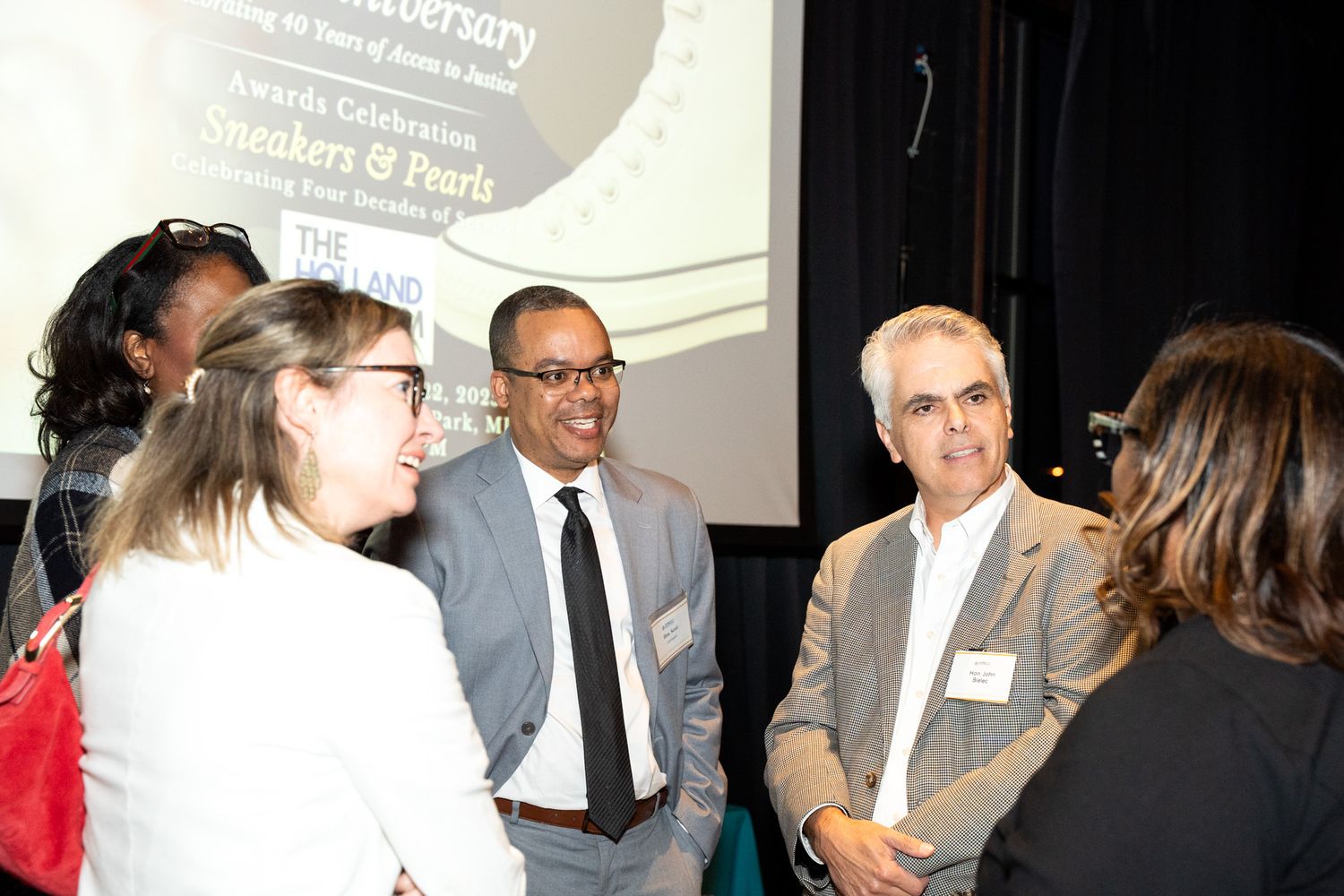 Small group engaged in business discussion at corporate event.