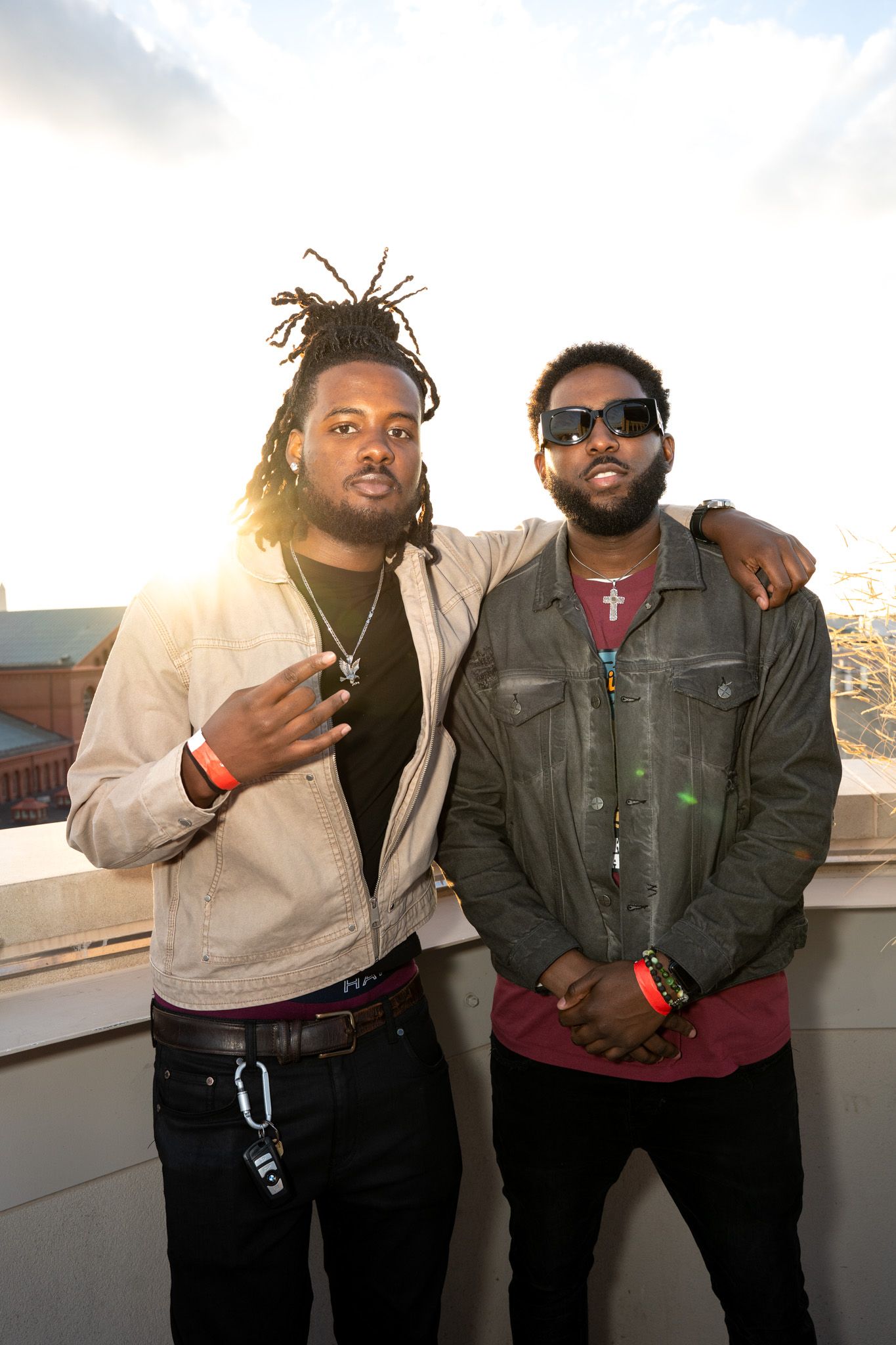 Two friends posing together outdoors during sunset on a rooftop or terrace.
