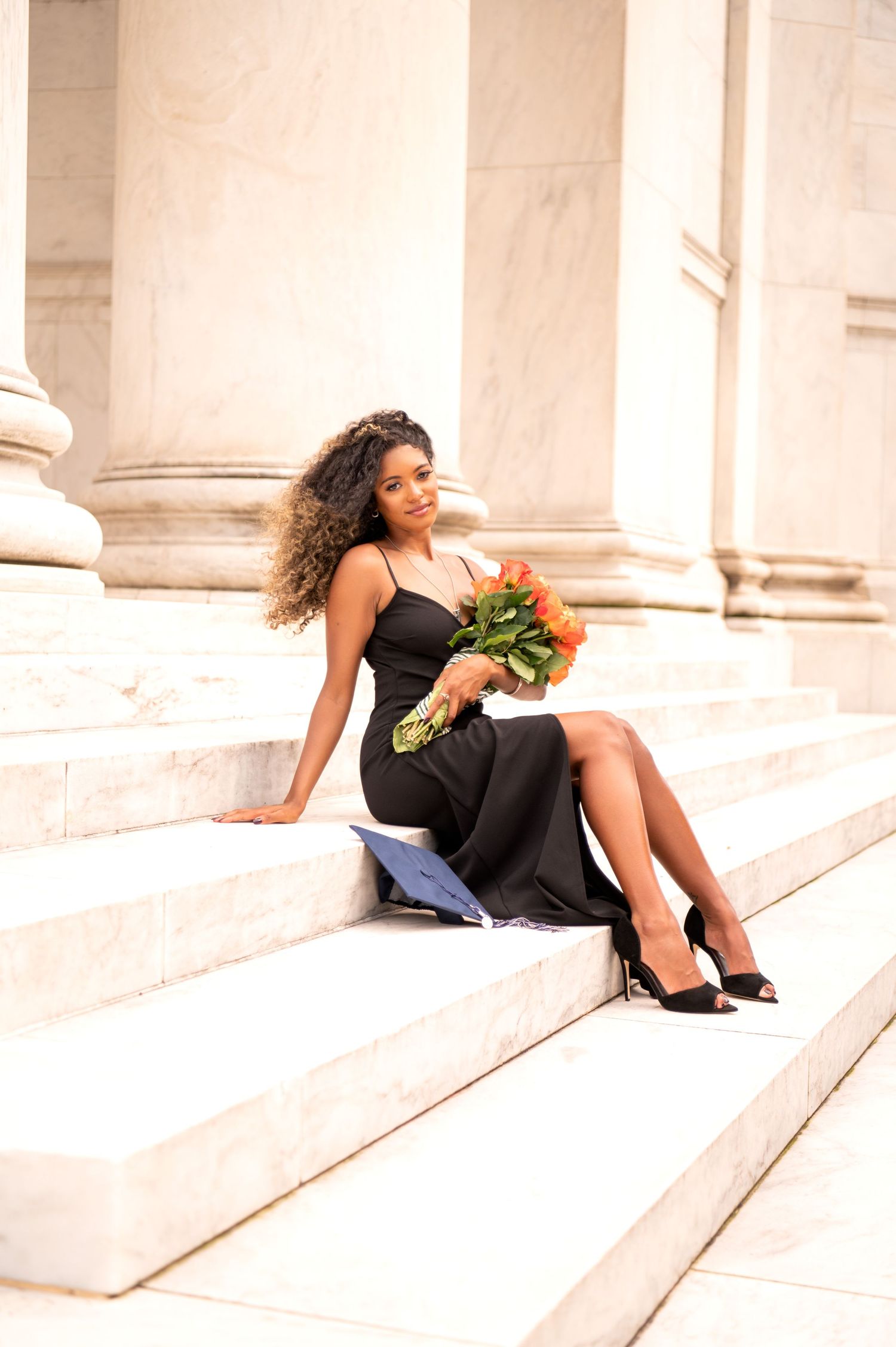 Portrait session on marble steps with black dress and flowers.