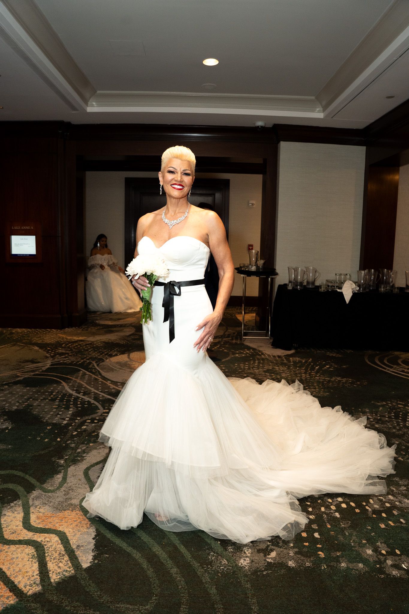 A bride in a flowing white ball gown with tulle skirt twirls and poses in an elegant indoor venue.