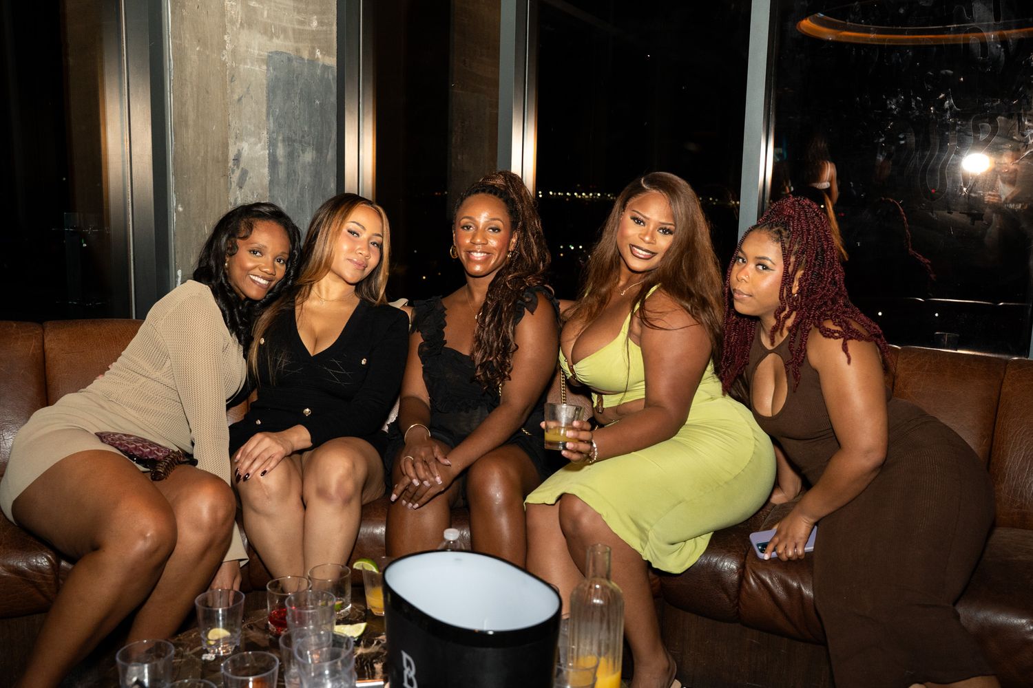 Friends relaxing and socializing at a dimly lit lounge area.
