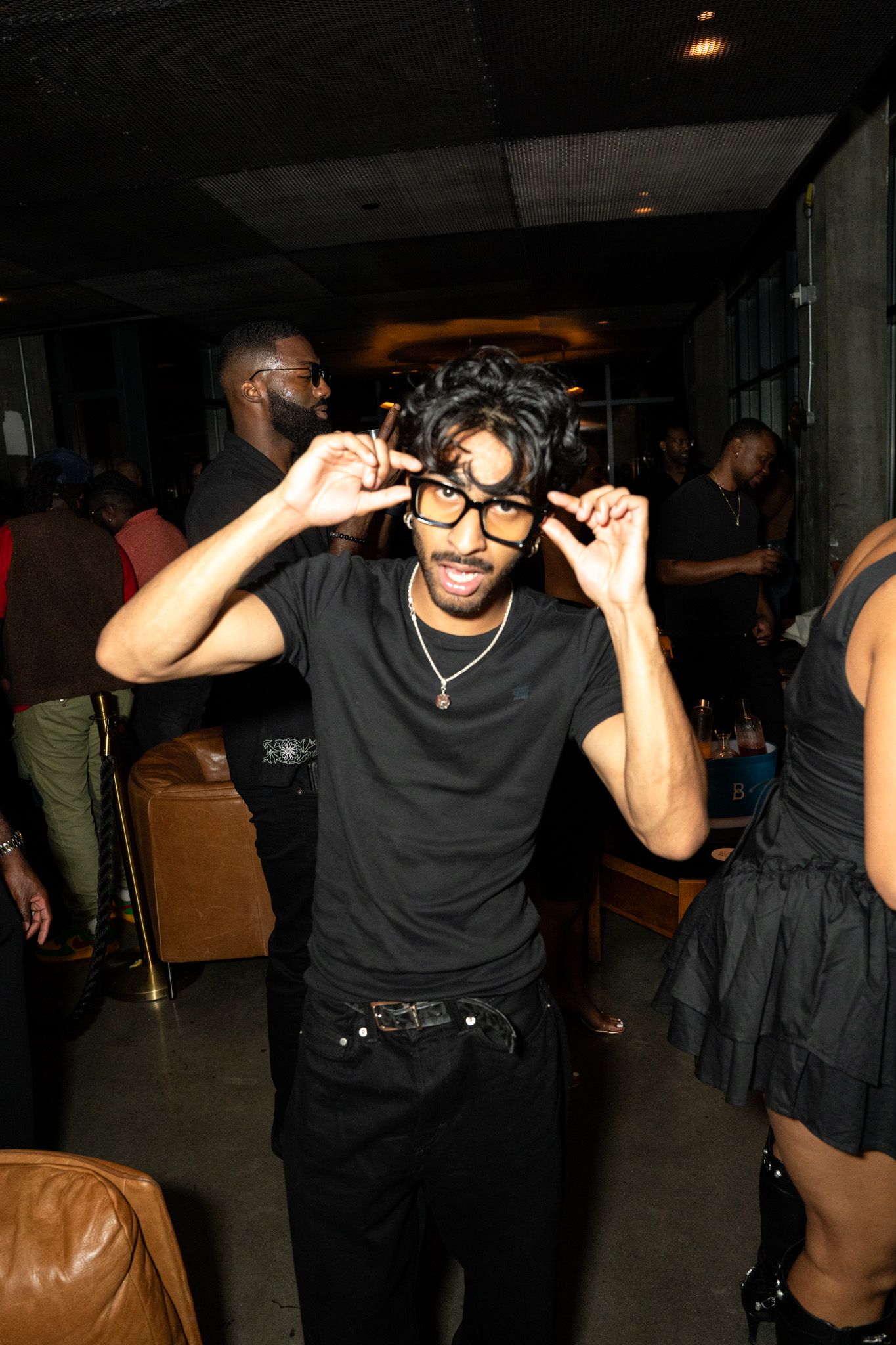 People dancing and posing in a dark club atmosphere.