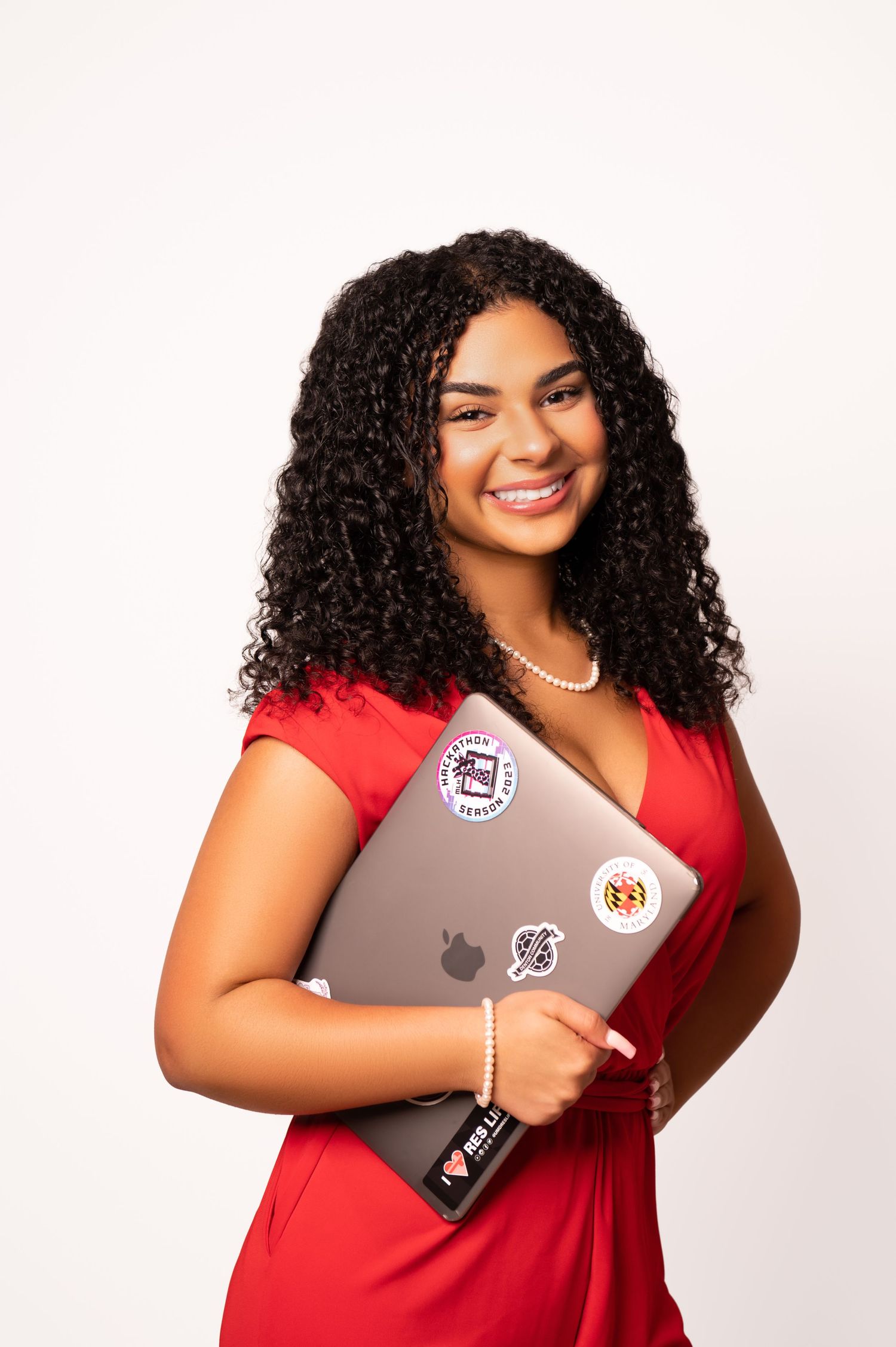 Business portraits with laptop and red dress against white background.
