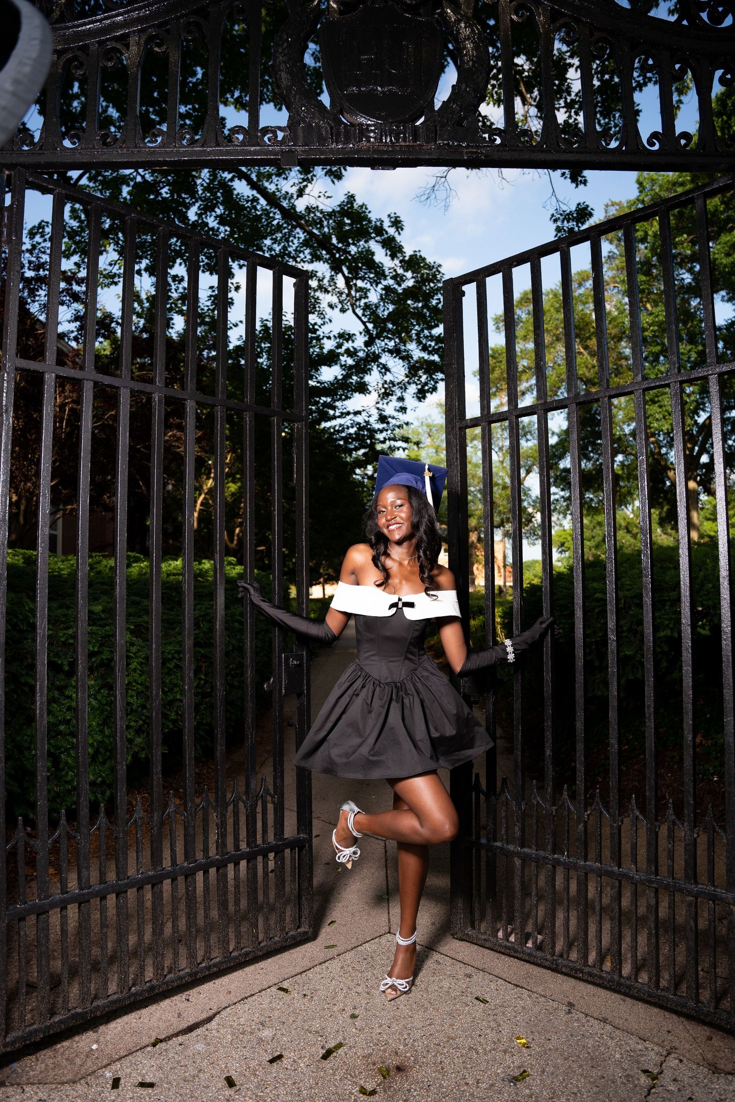 A series of creative dance movements photographed in front of decorative iron gates.