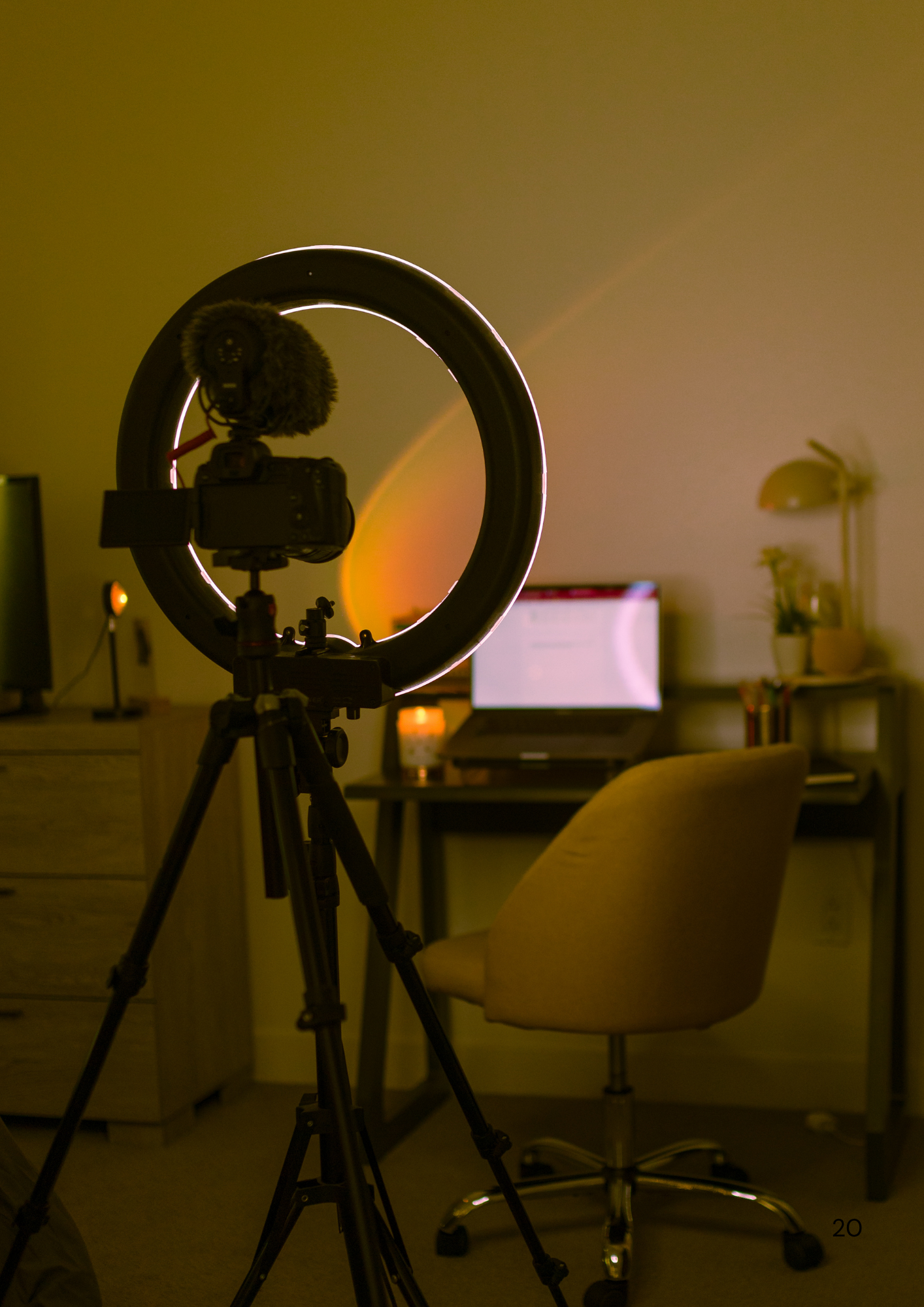 Professional studio setup with ring light and chair silhouetted against warm ambient lighting.