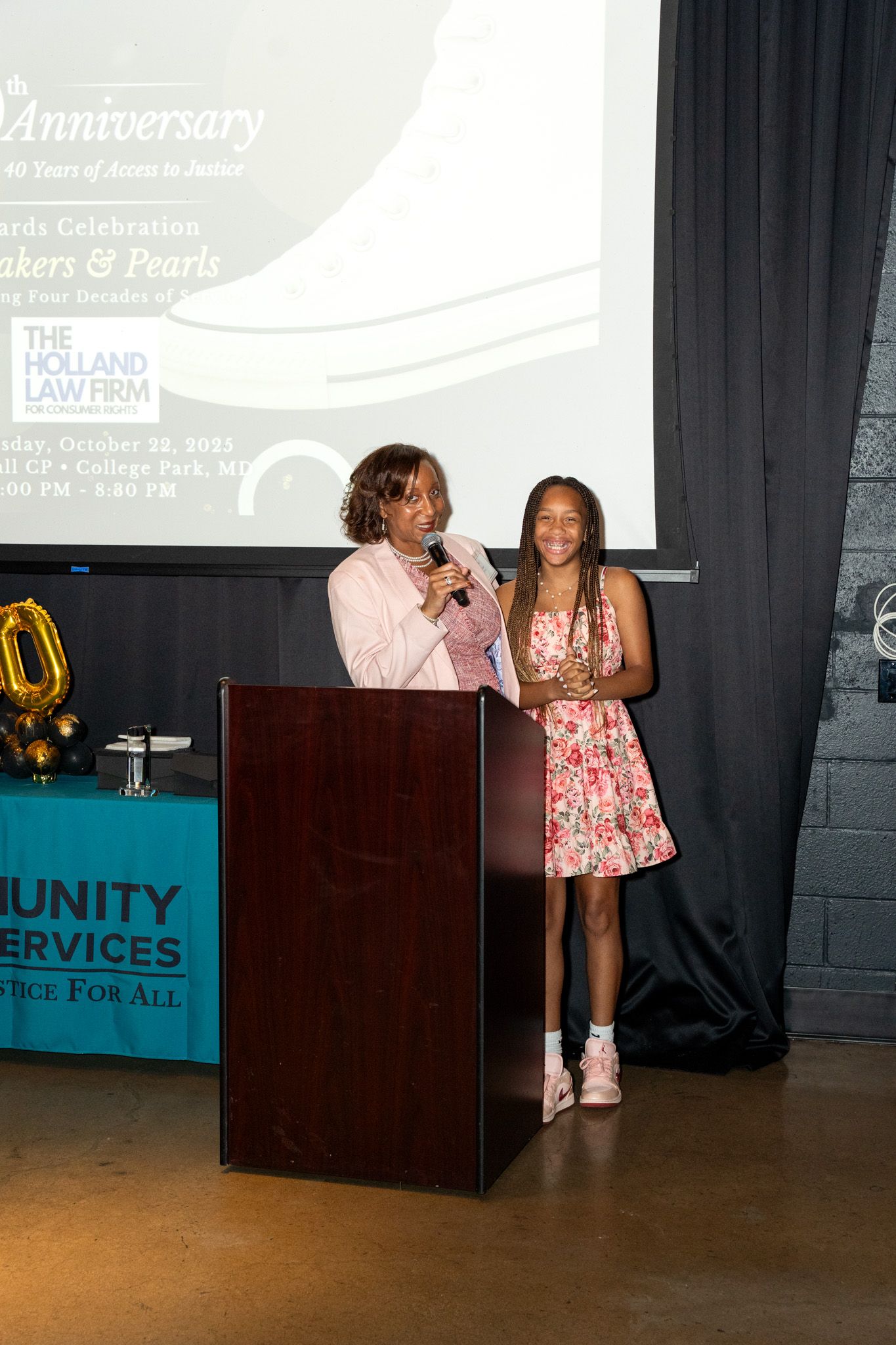 People gather near a podium at a corporate event with Unity Services signage visible in the background.