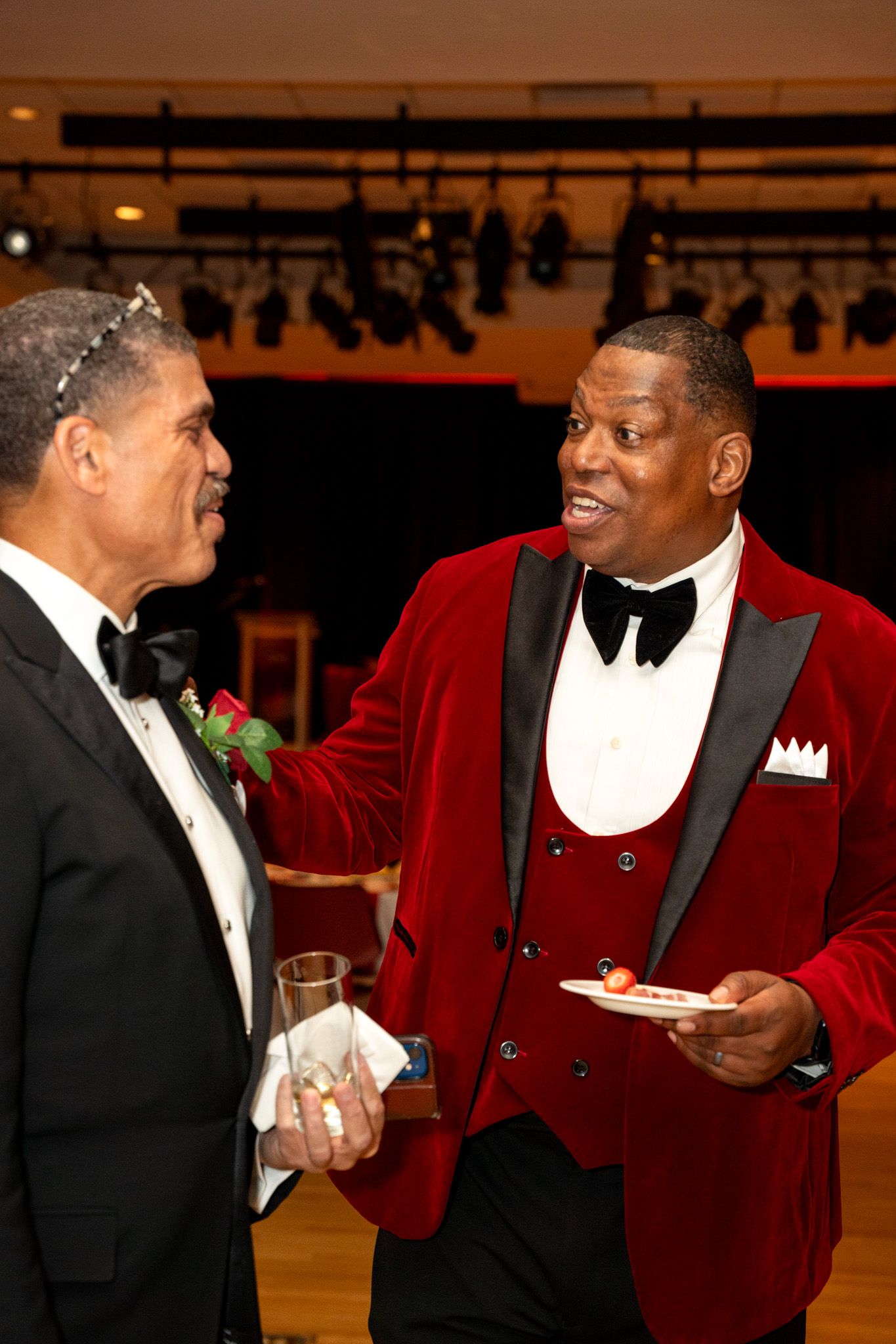 Two guests in formal wear sharing a moment at an elegant evening function.
