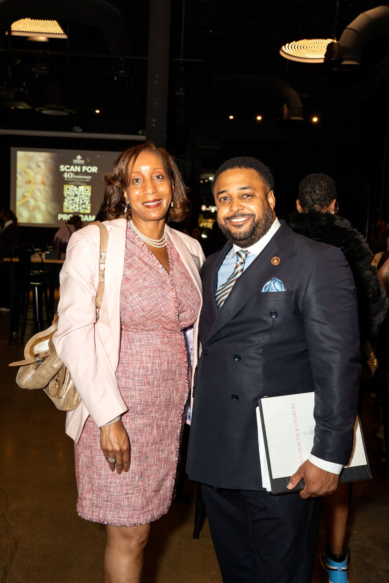 Professional attendees pose together at a formal networking event in business attire.