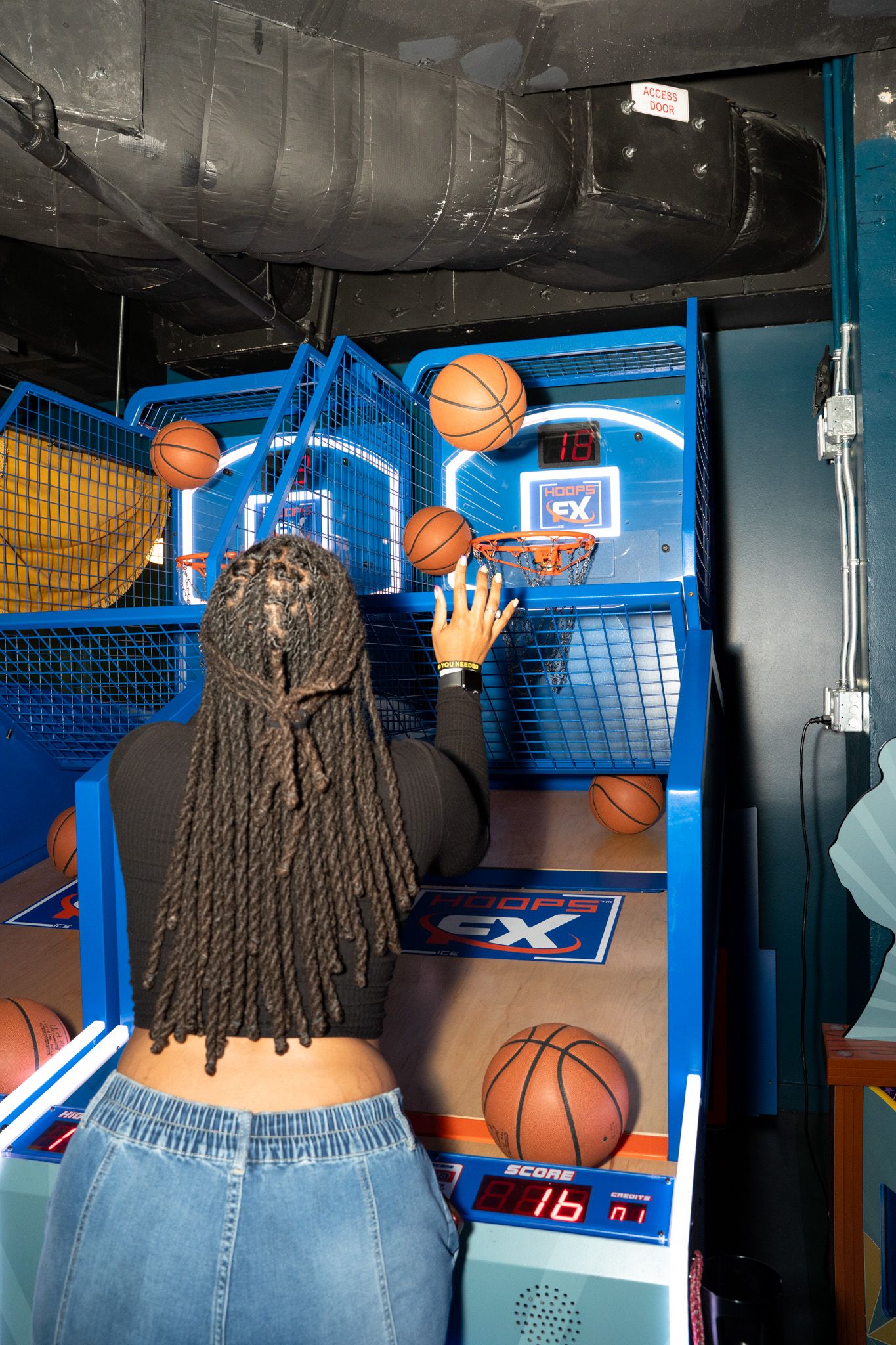 Basketball arcade game setup with neon lighting and multiple hoops.