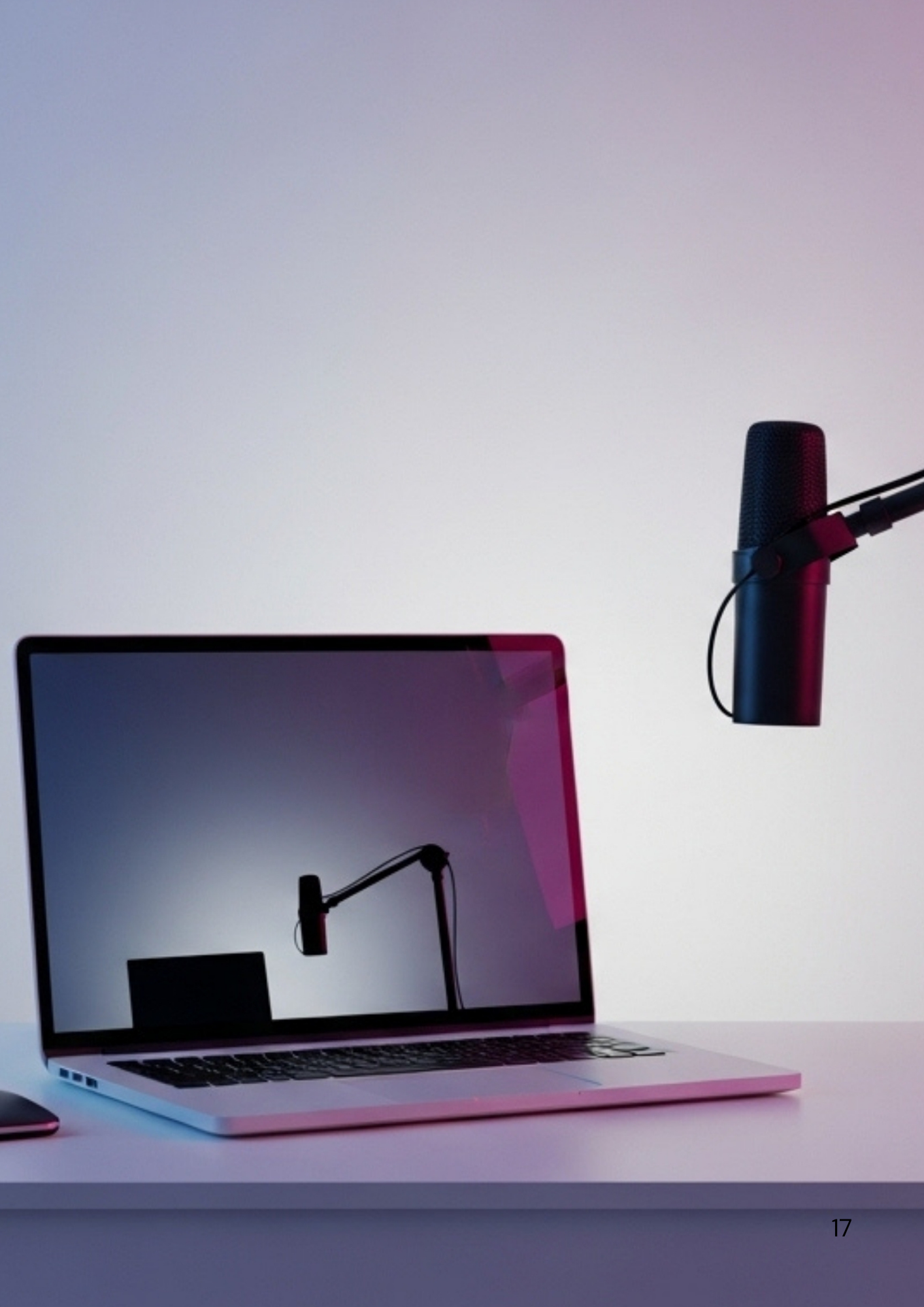 Professional content creation setup with laptop and microphone against gradient background.