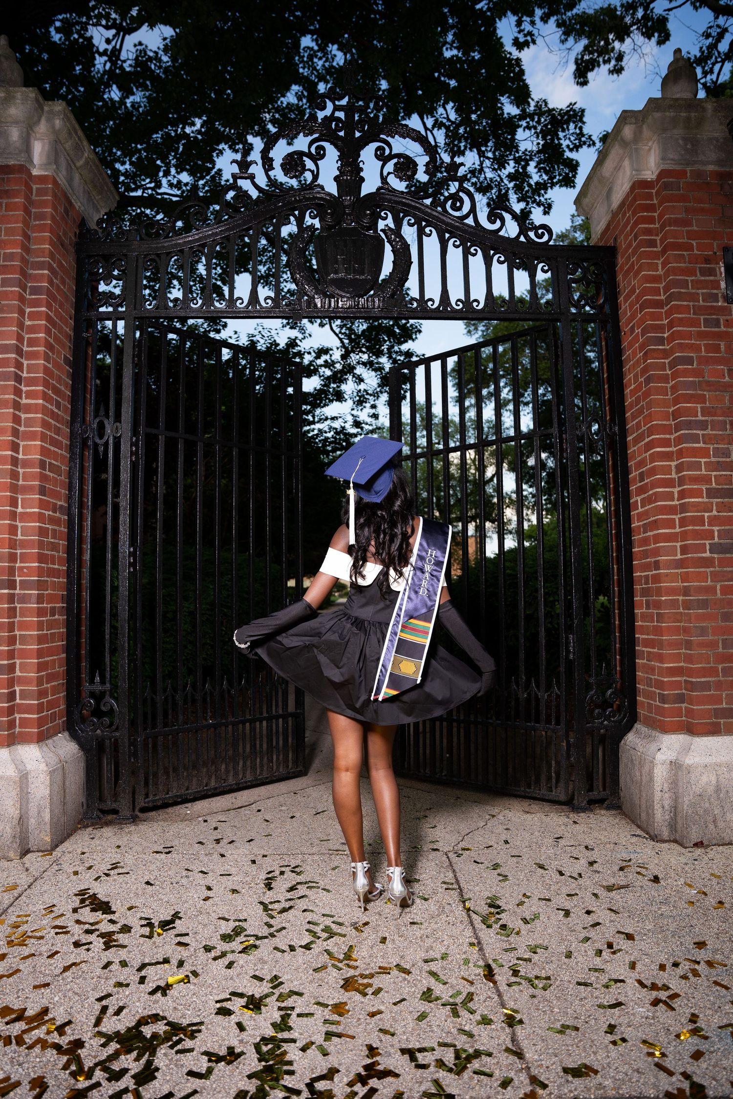 A series of expressive dance moves photographed by brick pillars and iron gates.