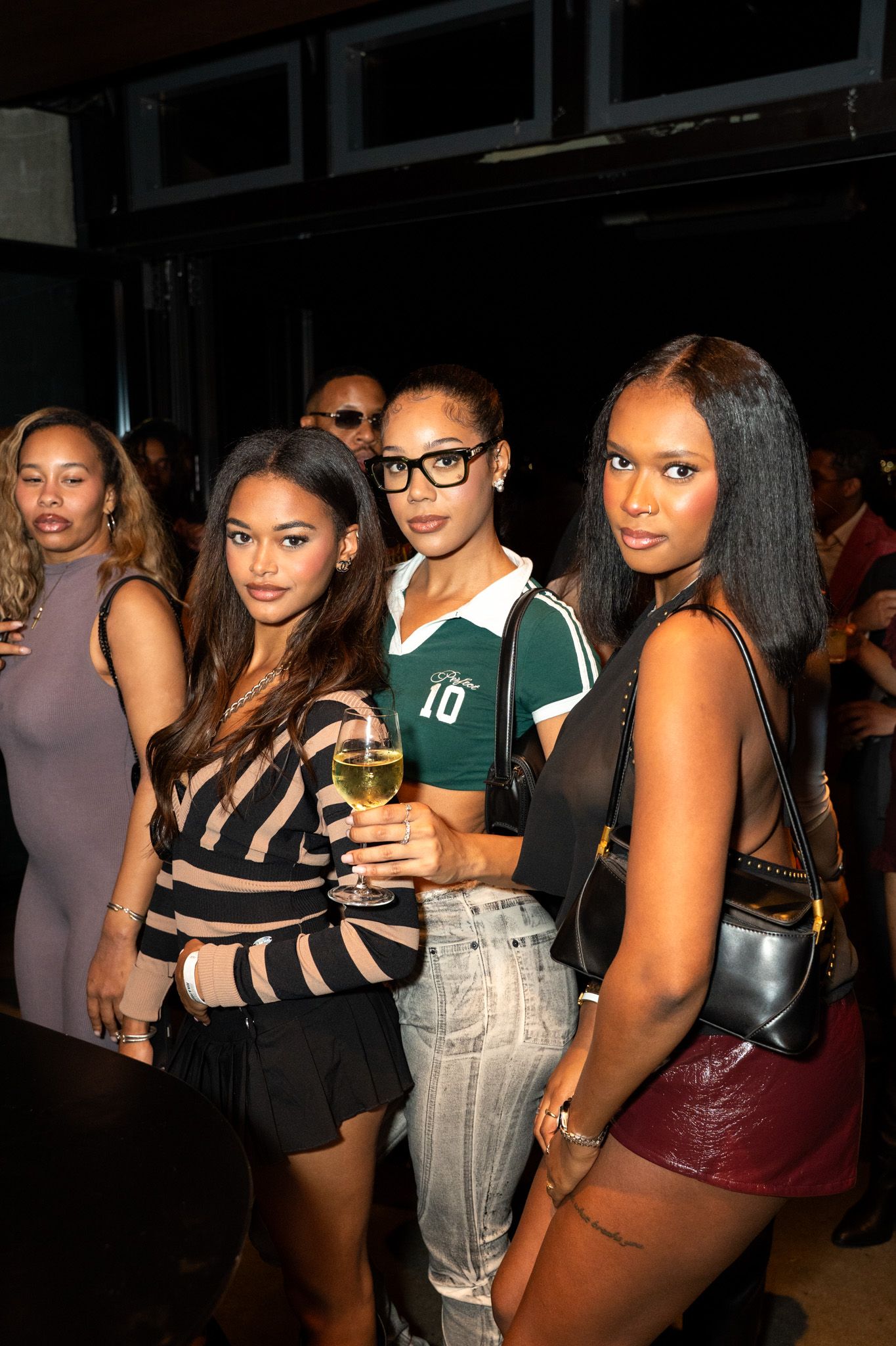 Group of party-goers socializing and enjoying drinks at a nightclub.