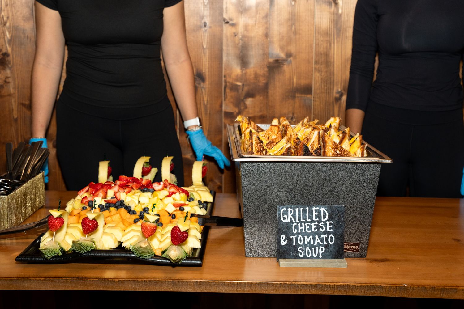 Catering display featuring appetizers and snacks on a rustic wooden table.
