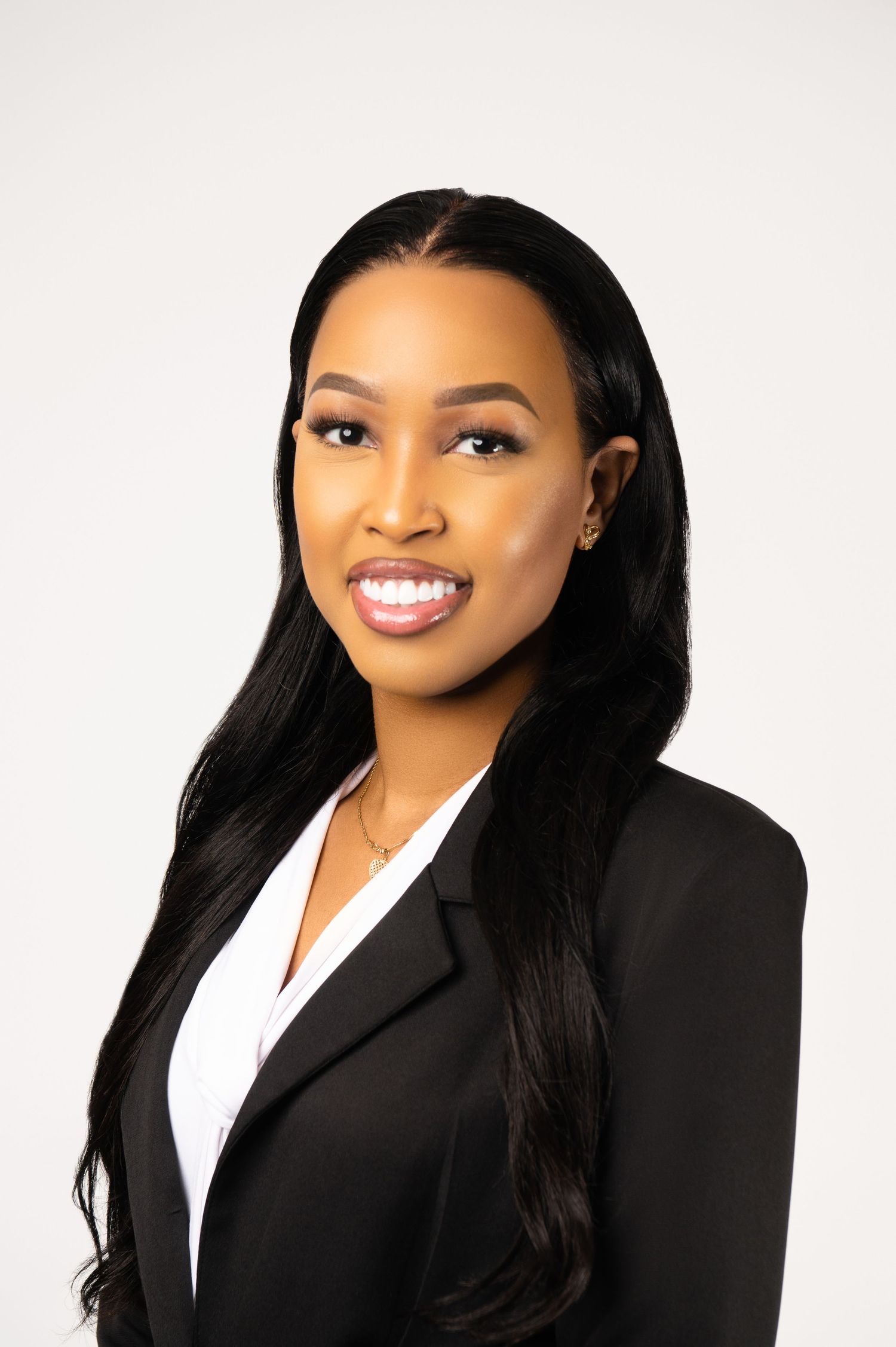 Corporate headshots in black blazer and white shirt against clean white background.