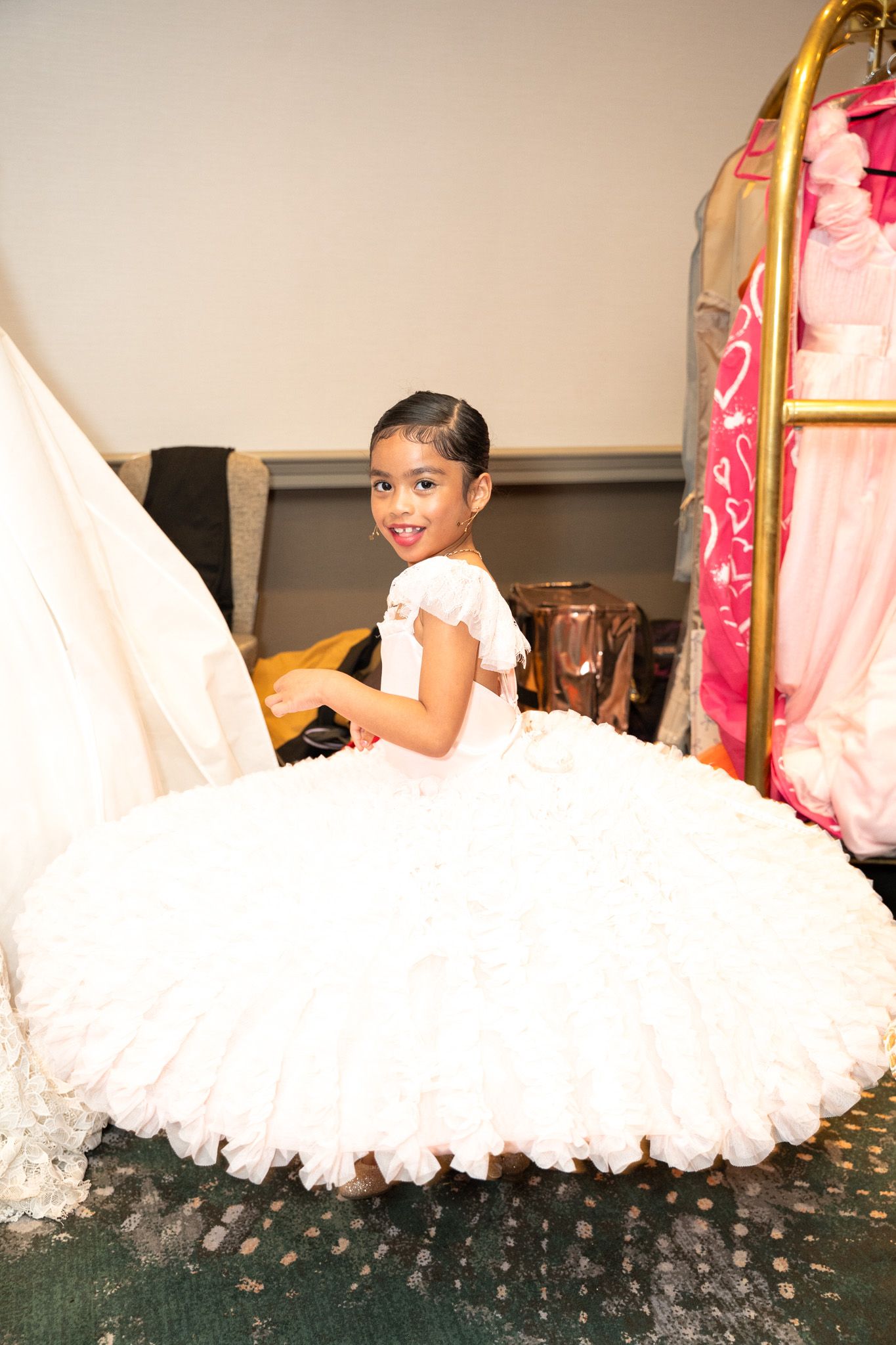 Model in white puffy dress twirls on runway showcasing dramatic movement of fabric.