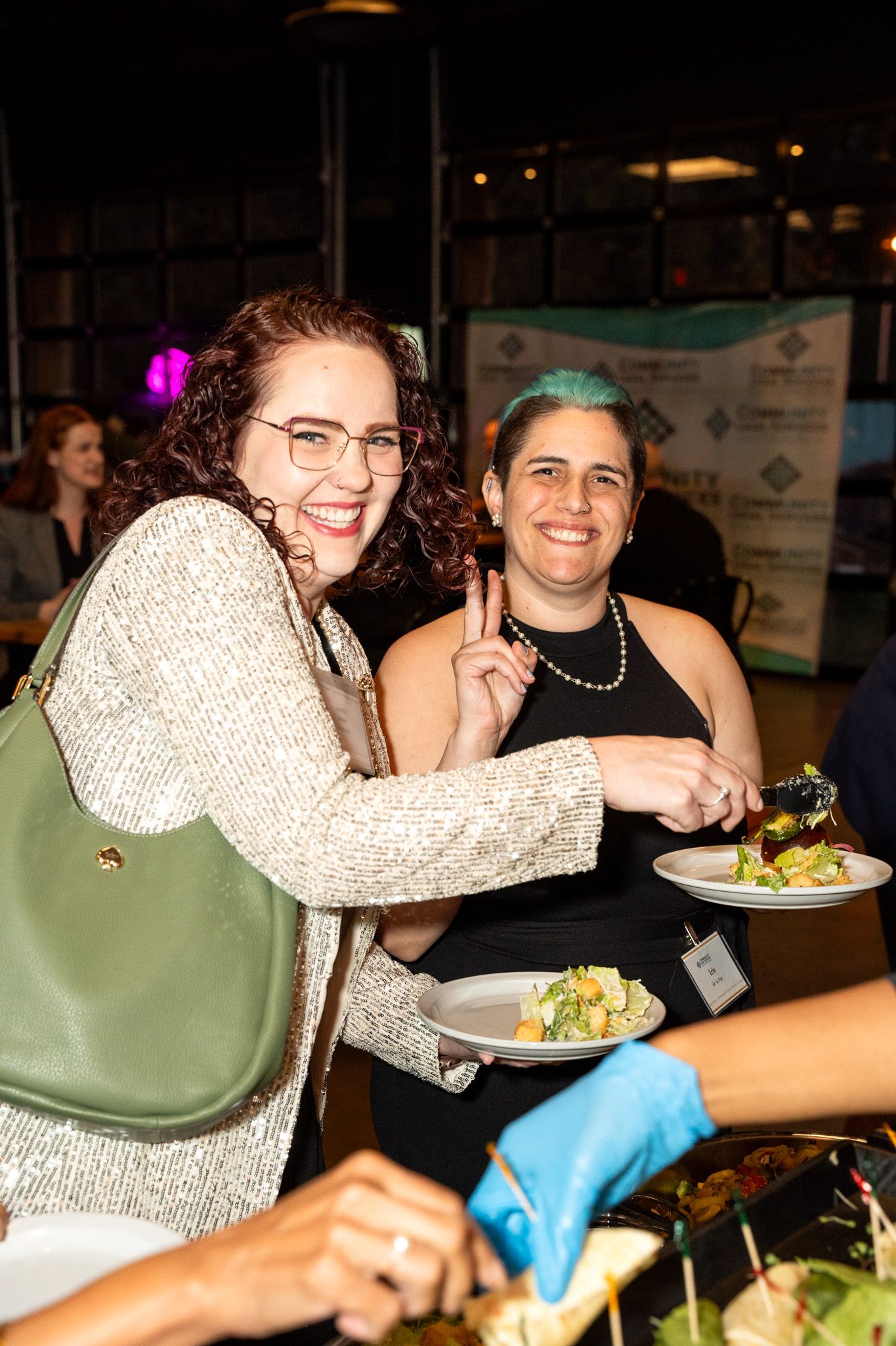 Two attendees enjoying food and conversation at a social gathering.