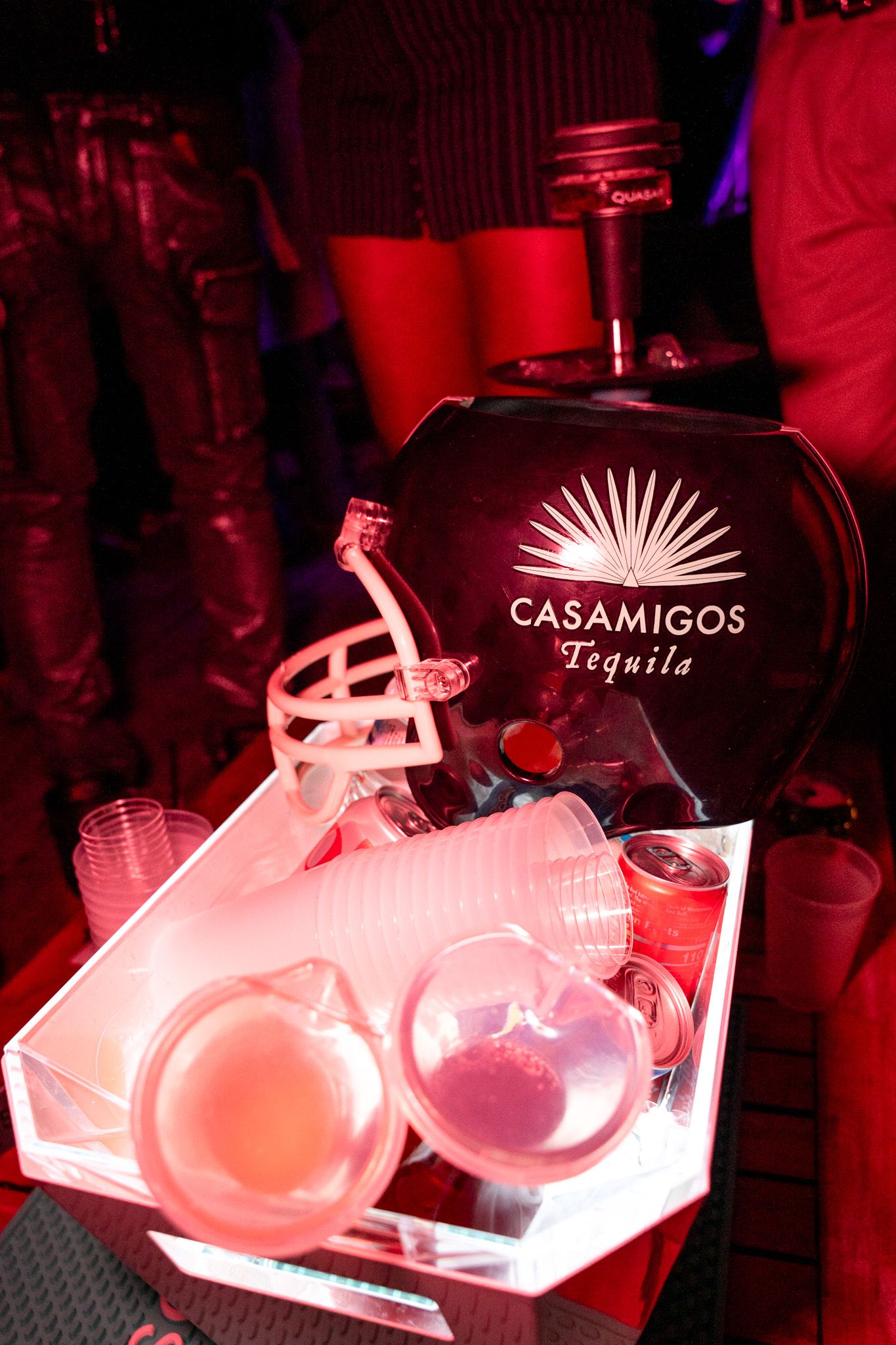 Illuminated Casamigos tequila display with pink lighting at a bar.