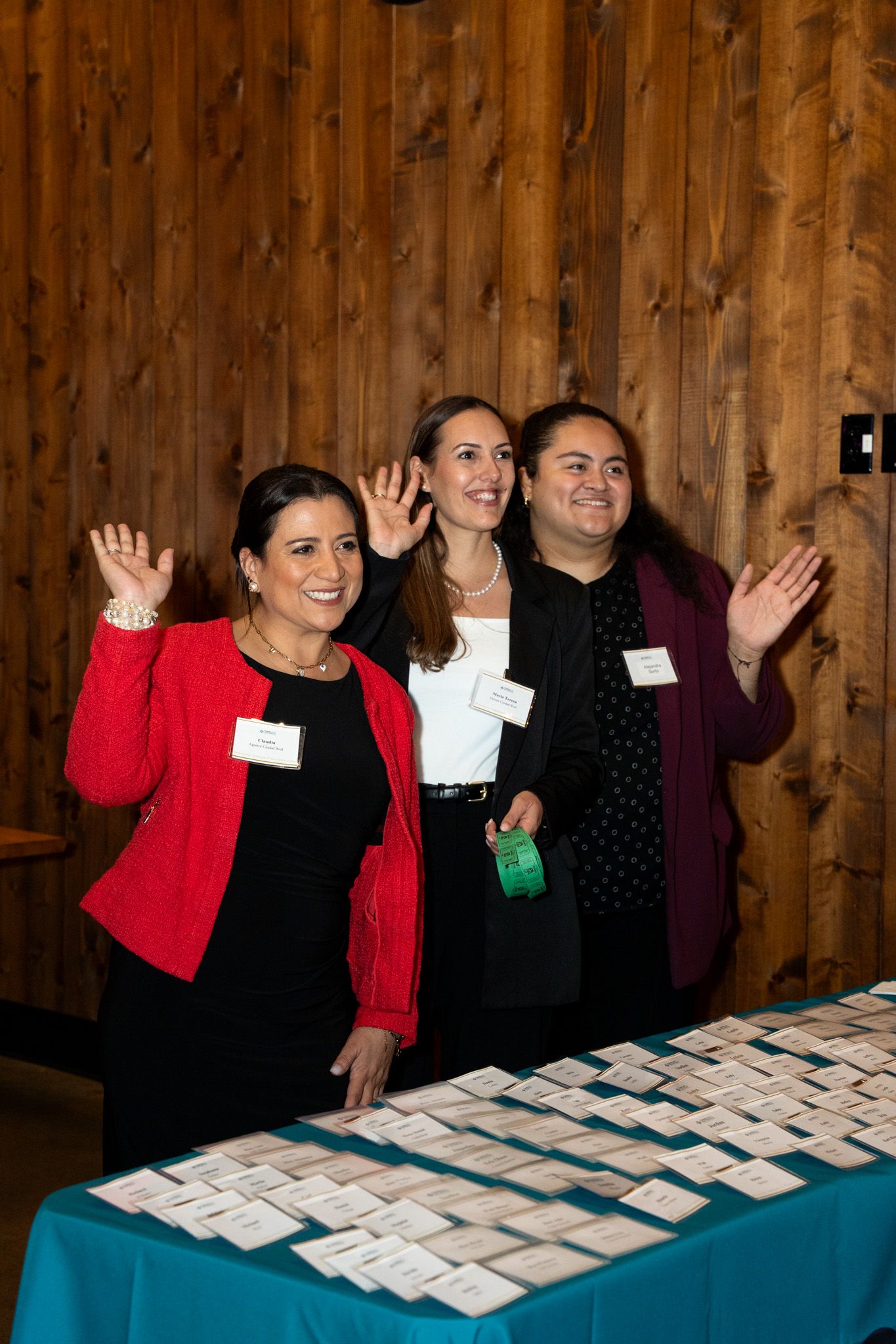 People standing behind a registration table with name tags at a professional event.