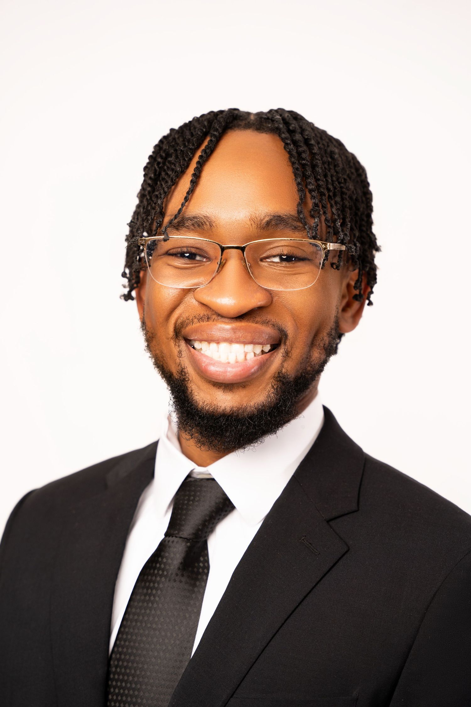 Professional headshots in black suit and tie with glasses against white background.