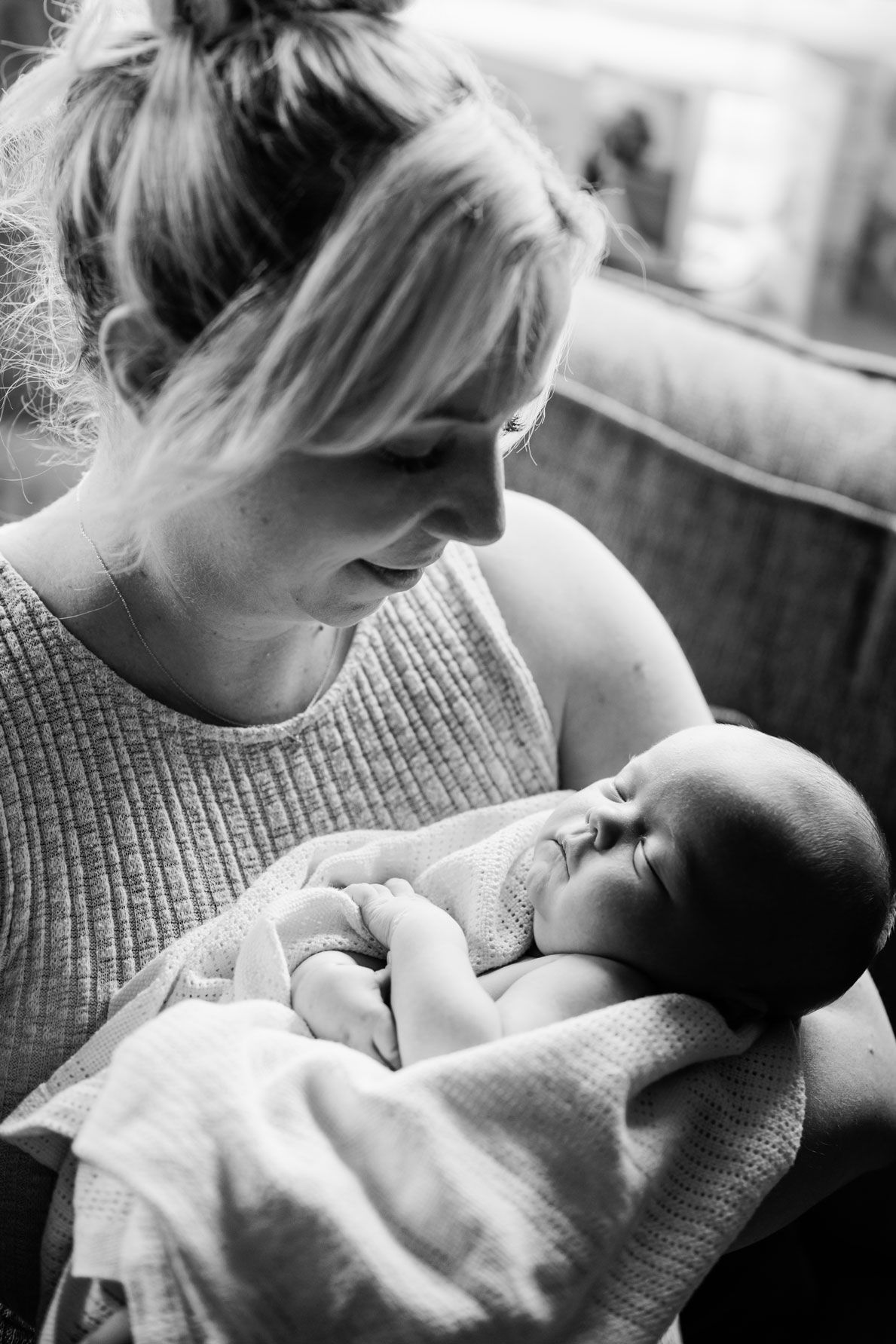 Mum cuddling her newborn baby during a relaxed lifestyle session at home