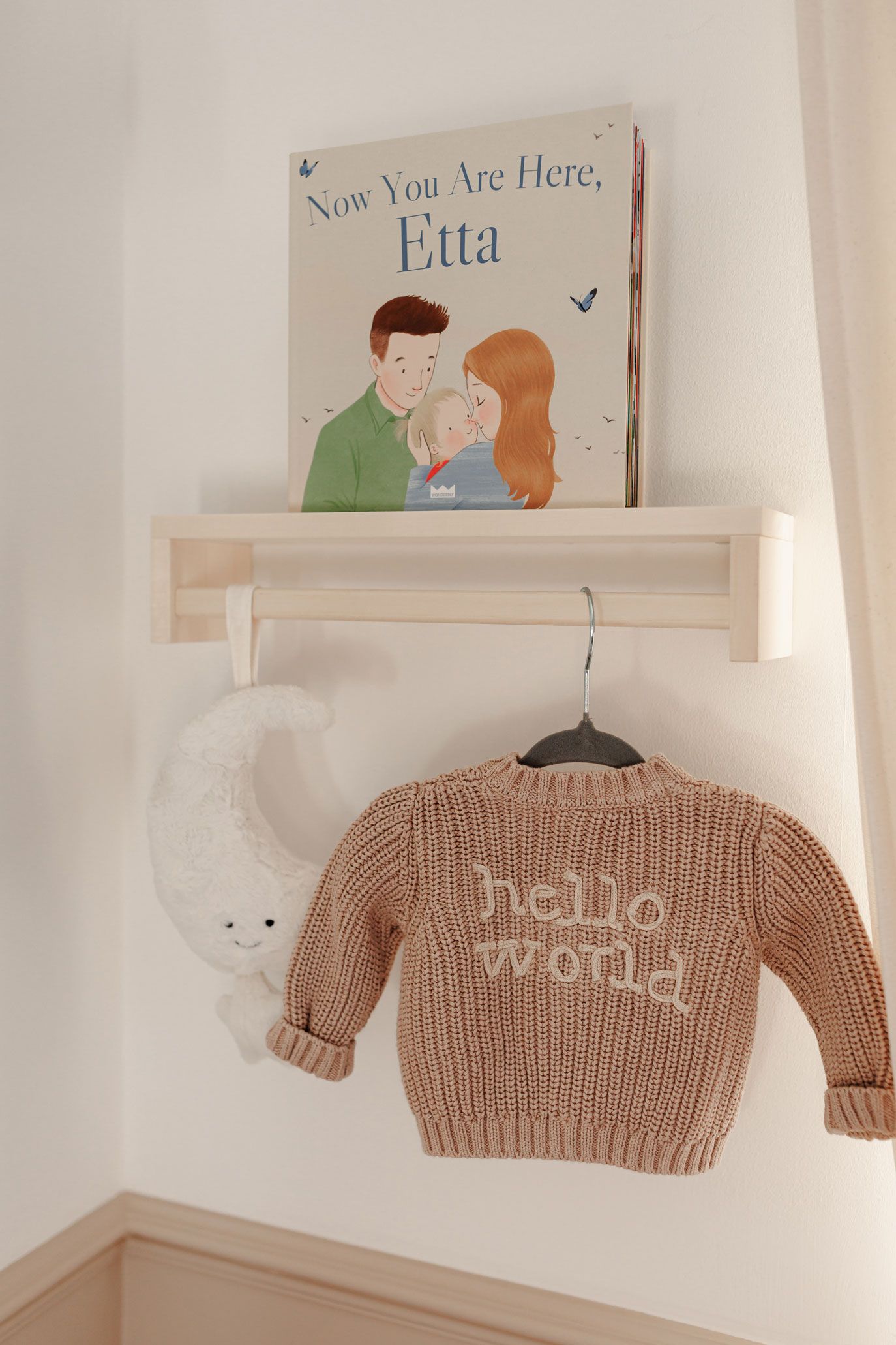 Personalised nursery details photographed during an at-home newborn photography session, featuring a custom baby book and knitted jumper