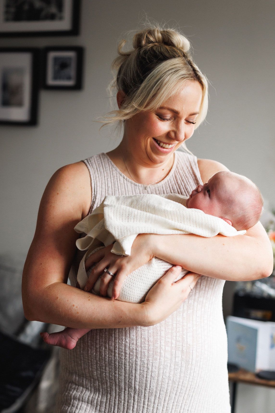 Mum cuddling her newborn baby during a relaxed lifestyle session at home