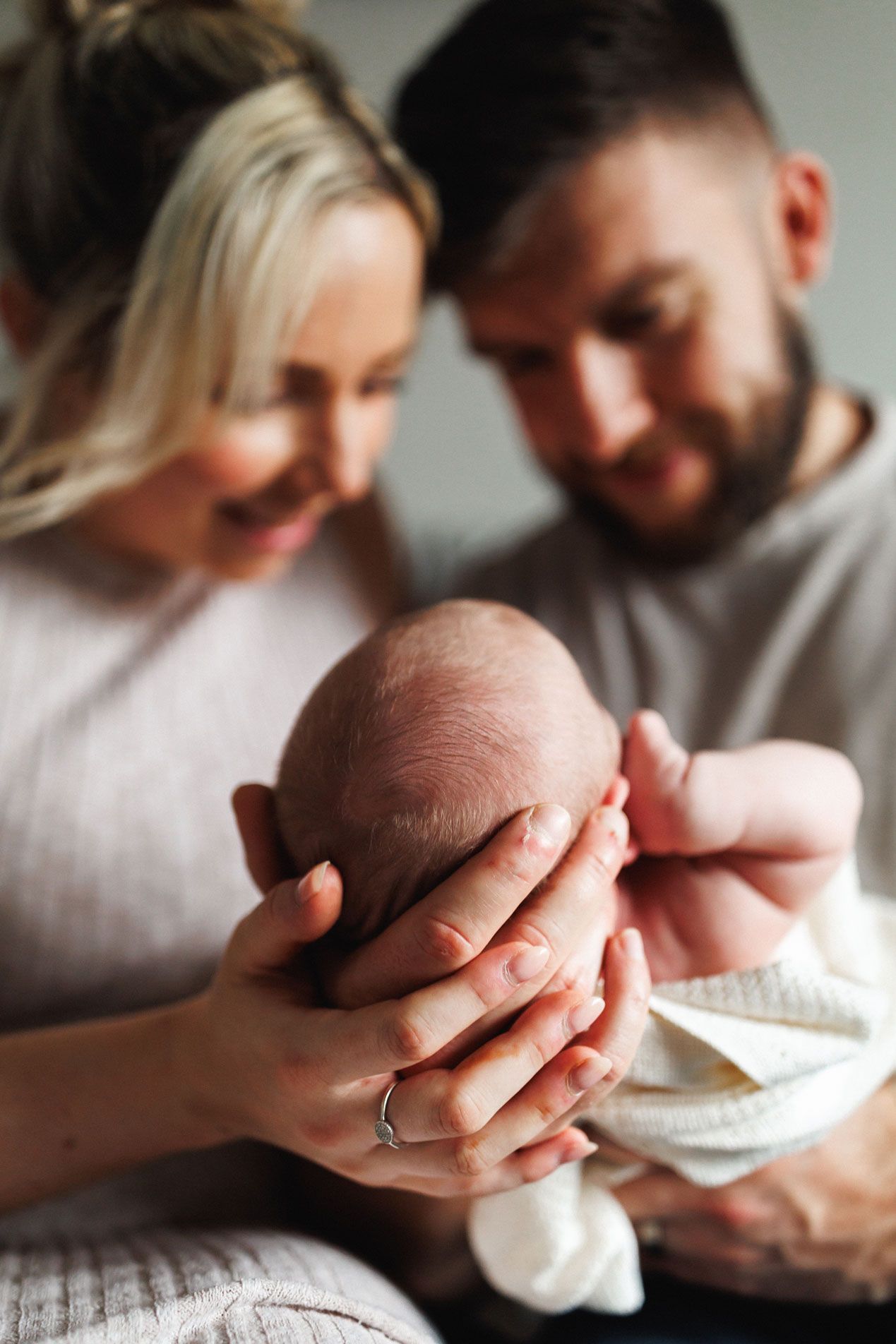 Family cuddling newborn Oliver during an at-home newborn photography session in Leicestershire