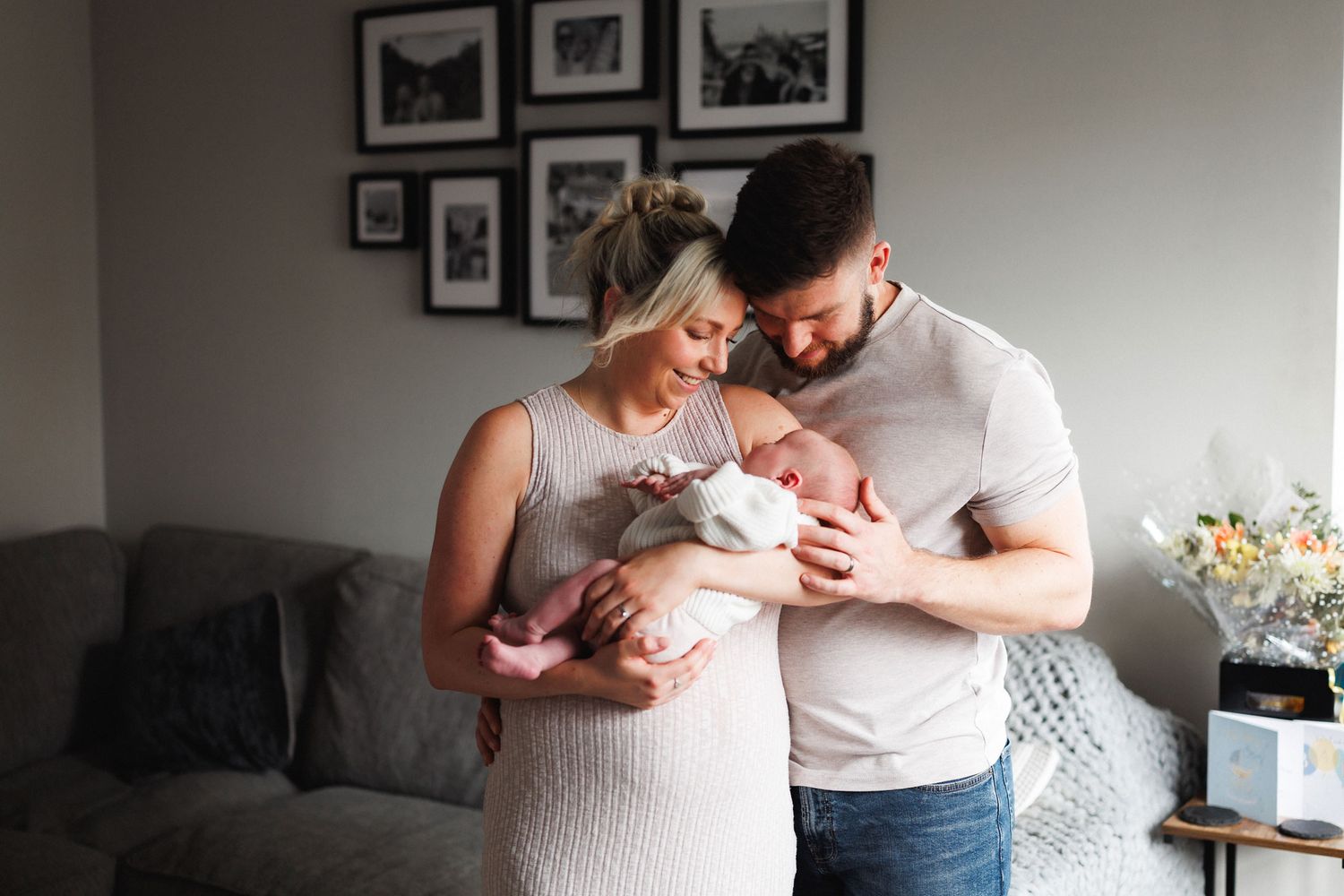 Family cuddling newborn Oliver during an at-home newborn photography session in Leicestershire