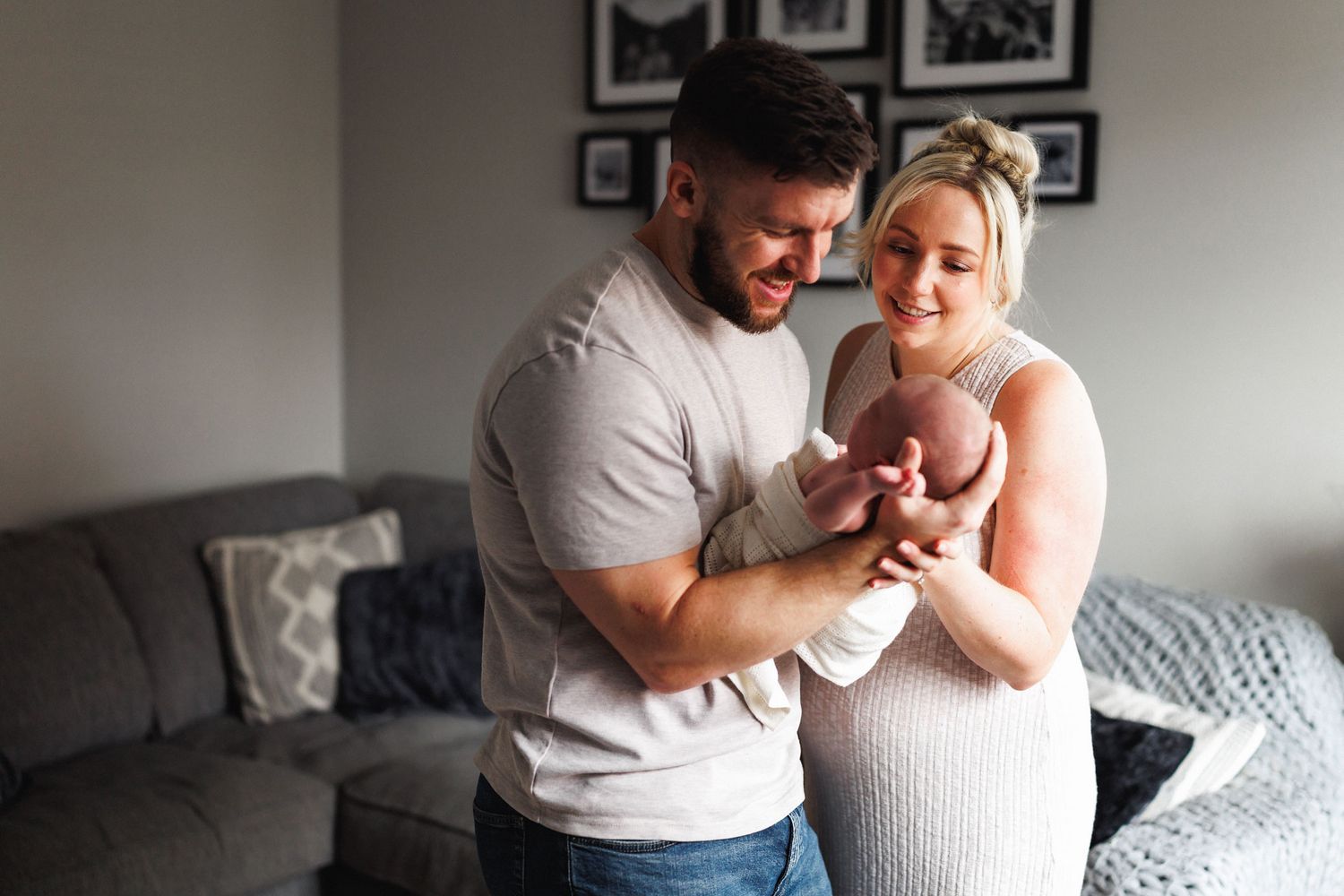Family cuddling newborn Oliver during an at-home newborn photography session in Leicestershire