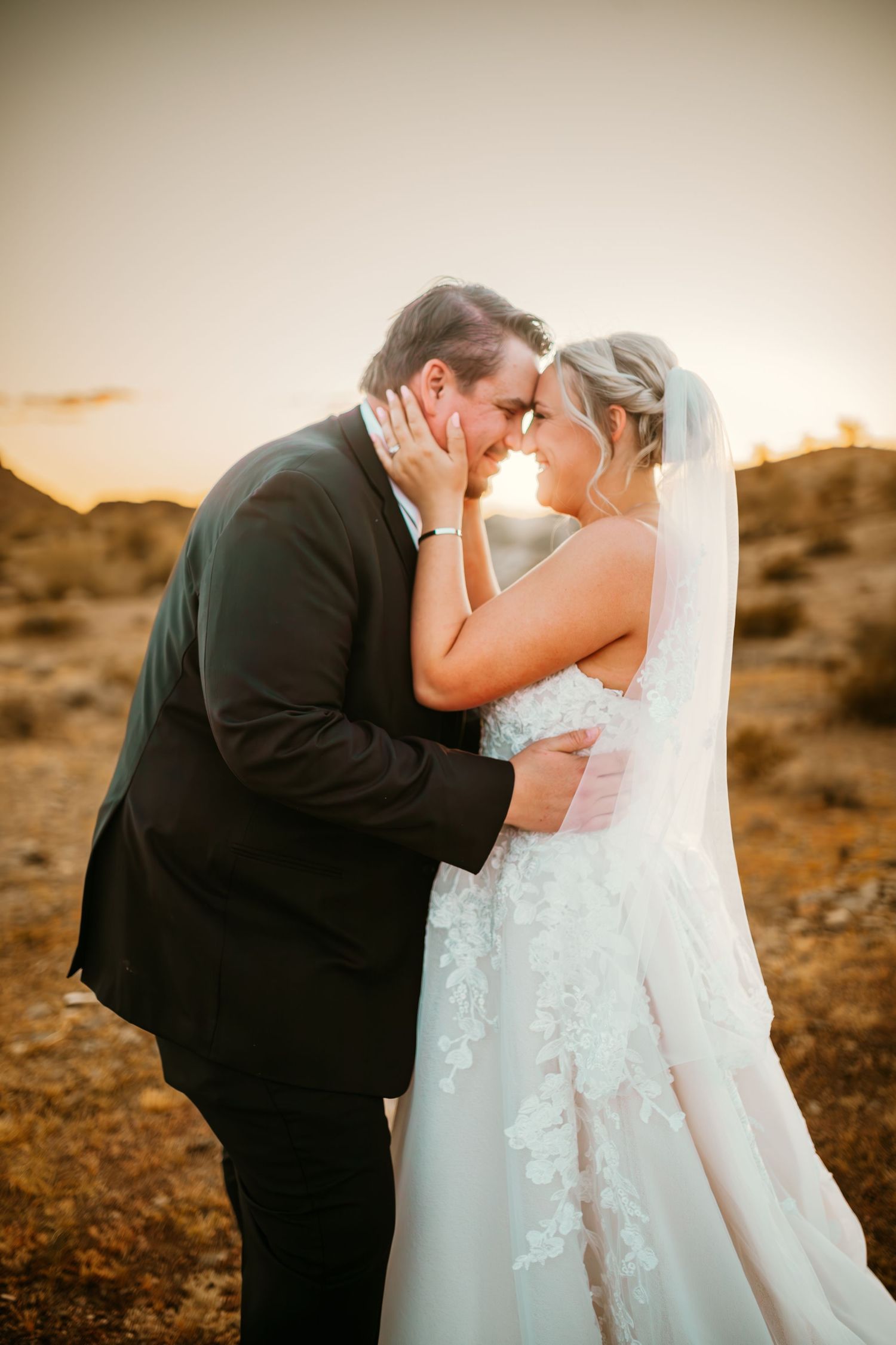 Sunset wedding portraits of couple embracing in Arizona desert