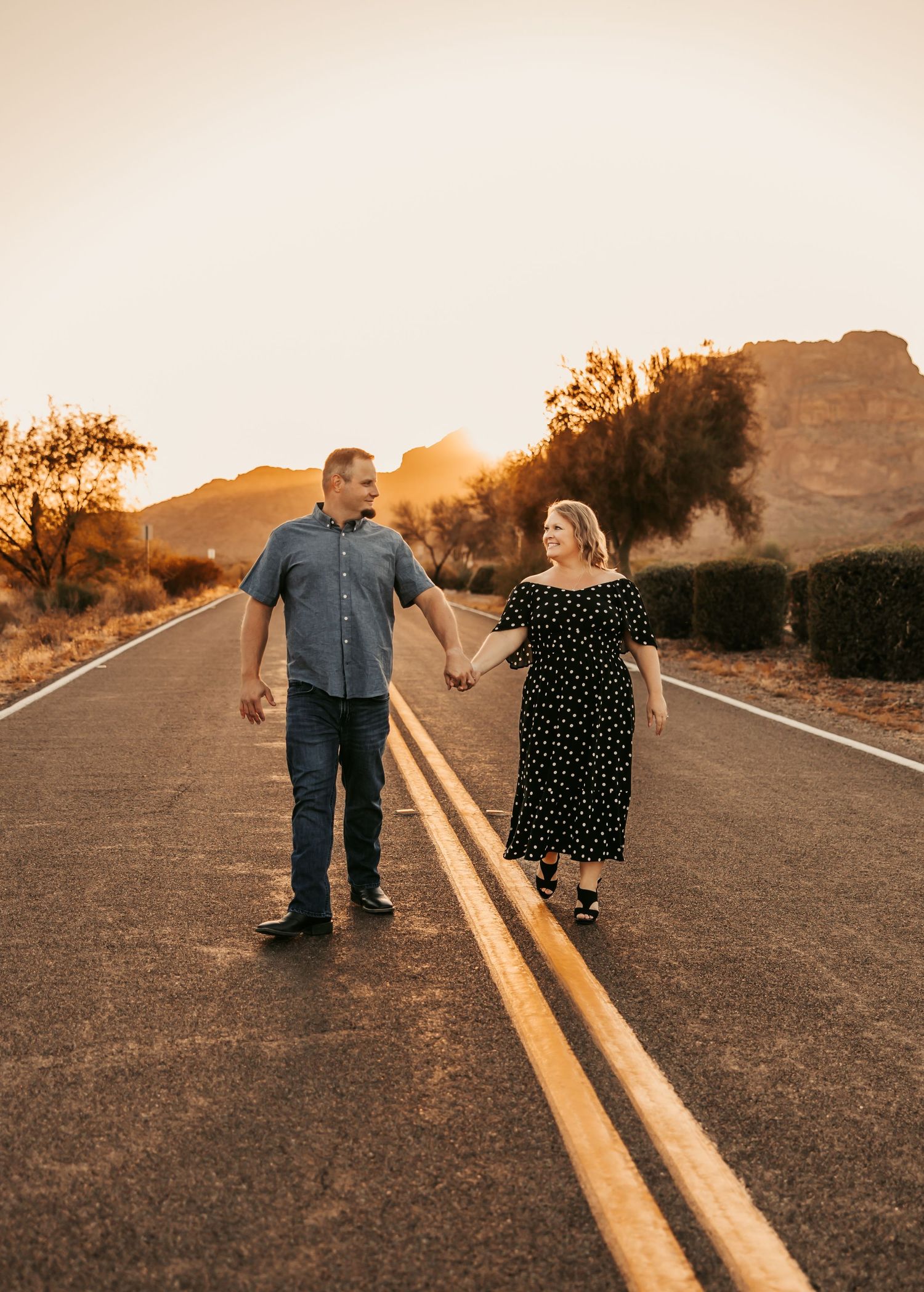Tiffany and Josh walking hand-in-hand in Arizona desert during golden-hour wedding session