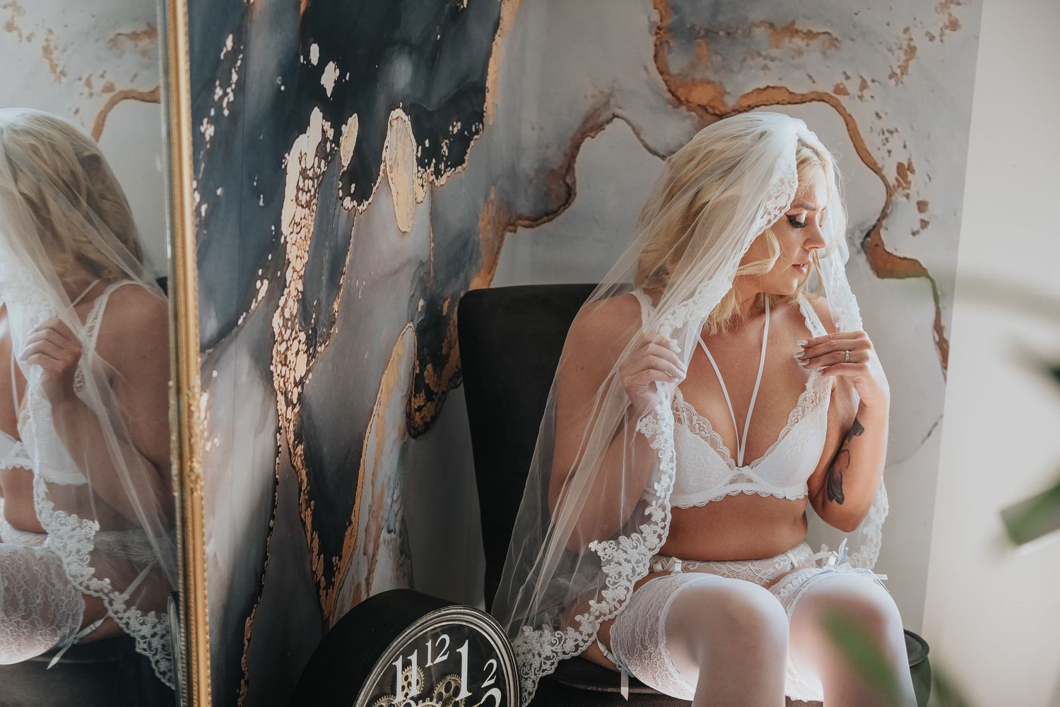 Boudoirporträtt i mjukt fönsterljus.
