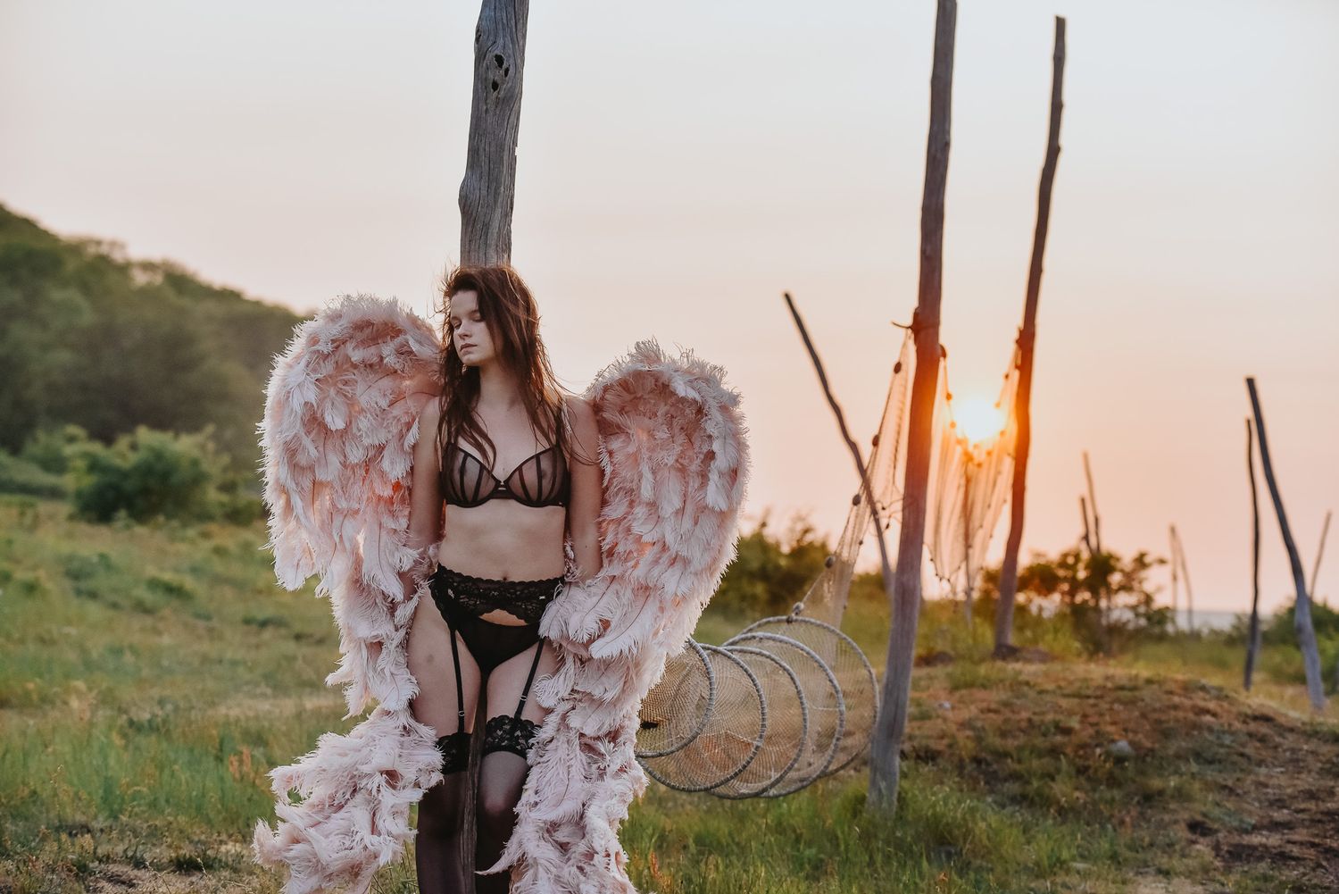 Änglavingar vid boudoirfotografering nere vid havet vid solnedgång