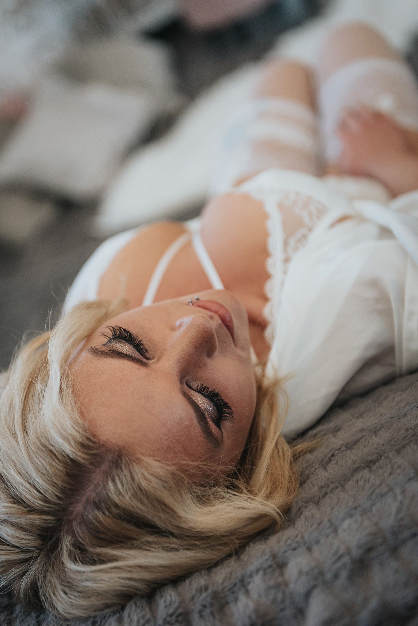Sensuell boudoirbild i morgonrock och vita romantiska underkläder.