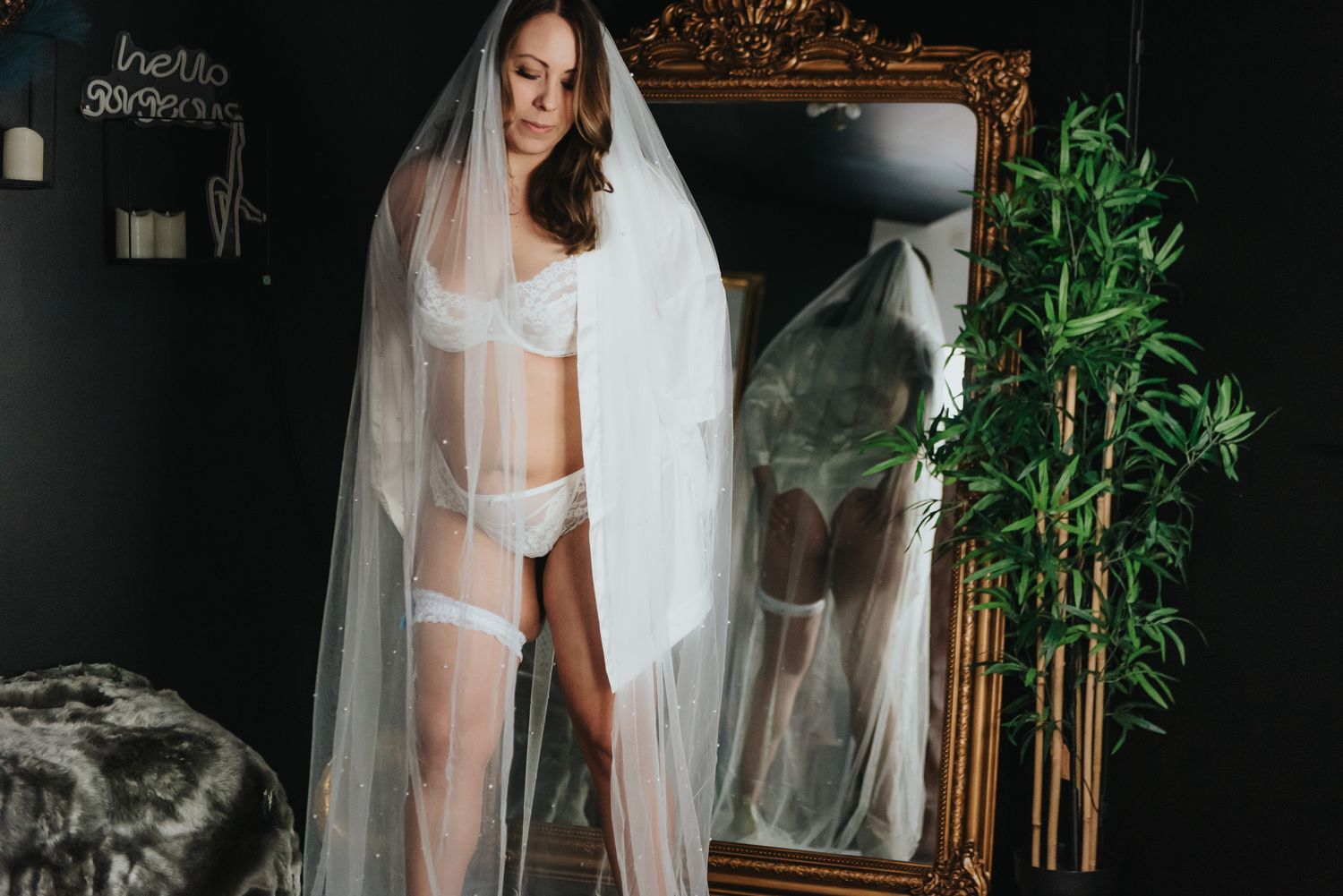 stilfull och sensuell pose framför spegel i boudoirstudio.
