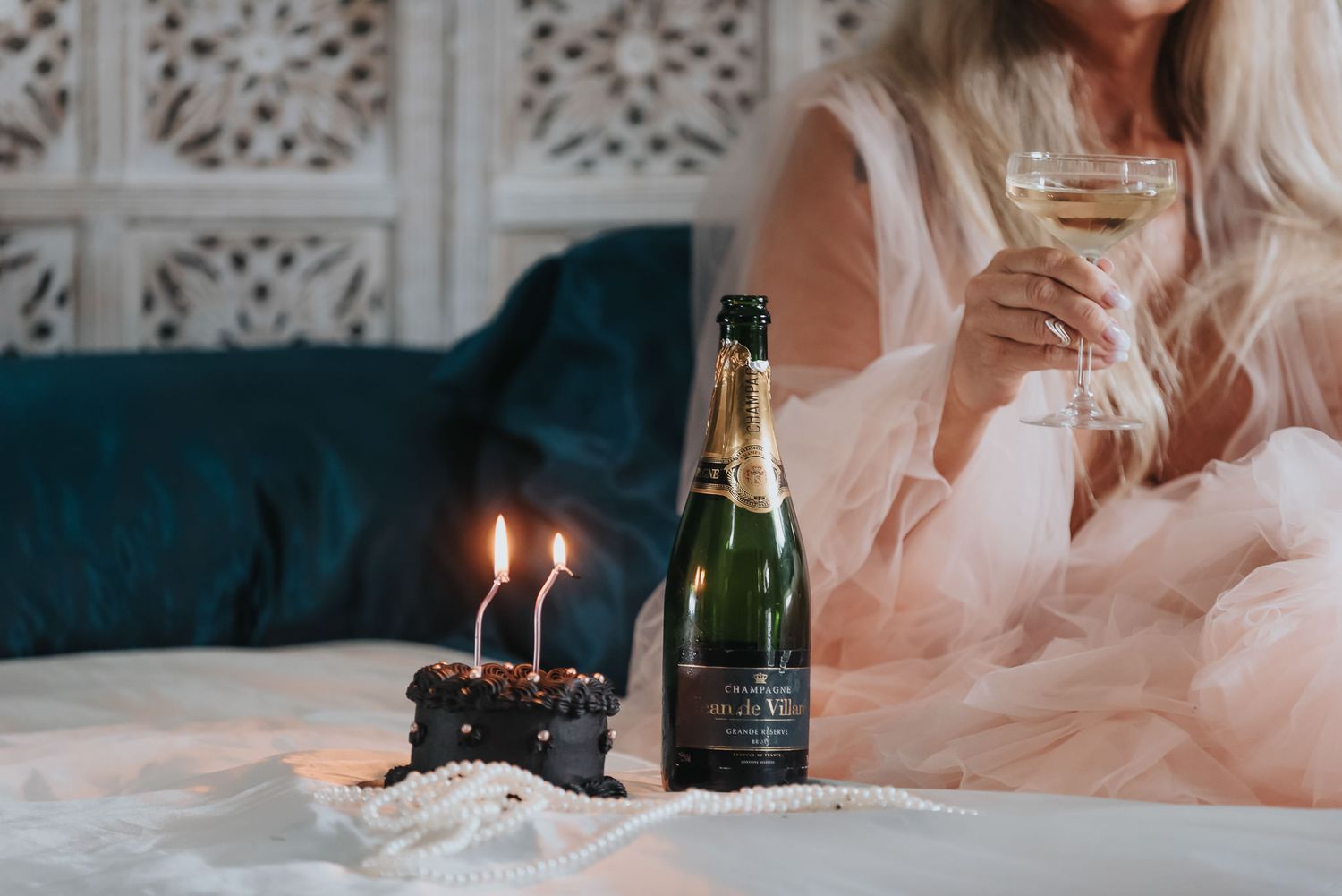 boudoirfotografering där kvinna firar sig själv med tårta och champagne