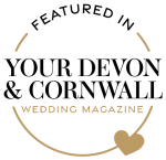 A professional photographer with a camera photographs a wedding scene in an elegant outdoor setting.