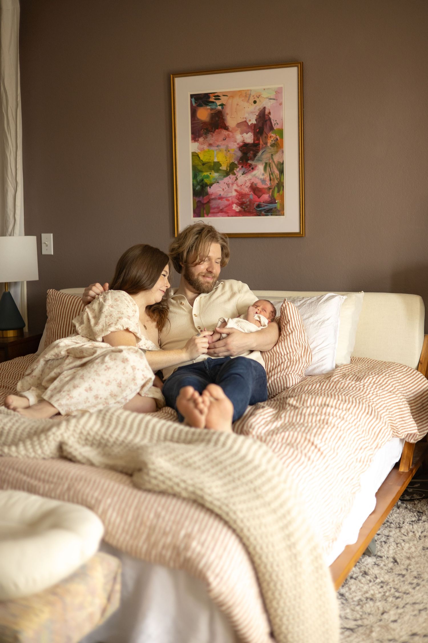 Family on bed holding newborn — lifestyle family photography in Tacoma, Puyallup, Gig Harbor, South Sound, Washington