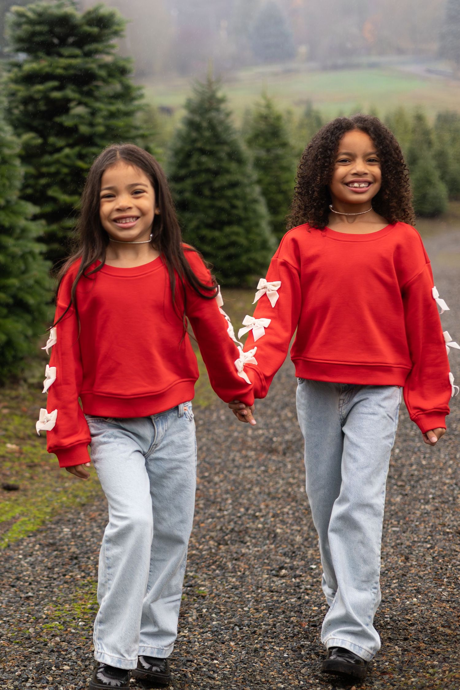 Sequence of photos showing a child in red sweater and jeans walking and twirling on a gravel path near evergreen trees.