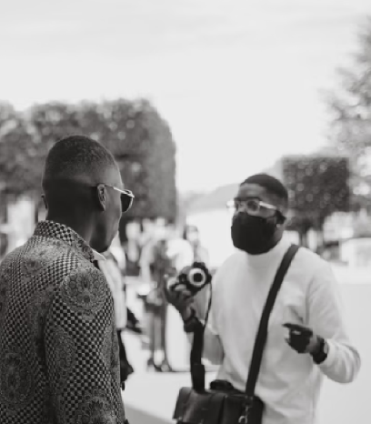 Two photographers engaging in conversation while one holds a camera.