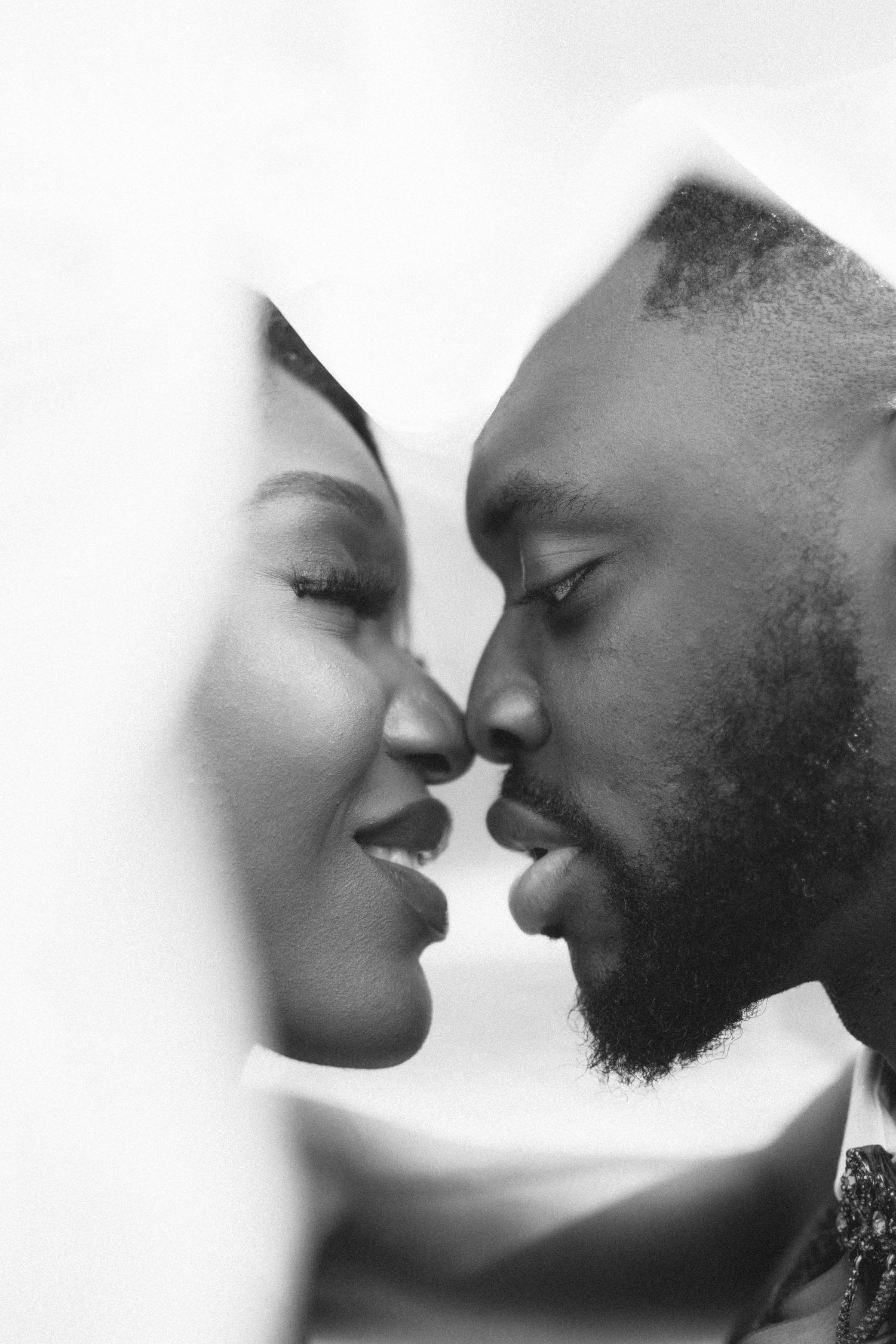 A black and white intimate portrait of a couple sharing a tender moment.