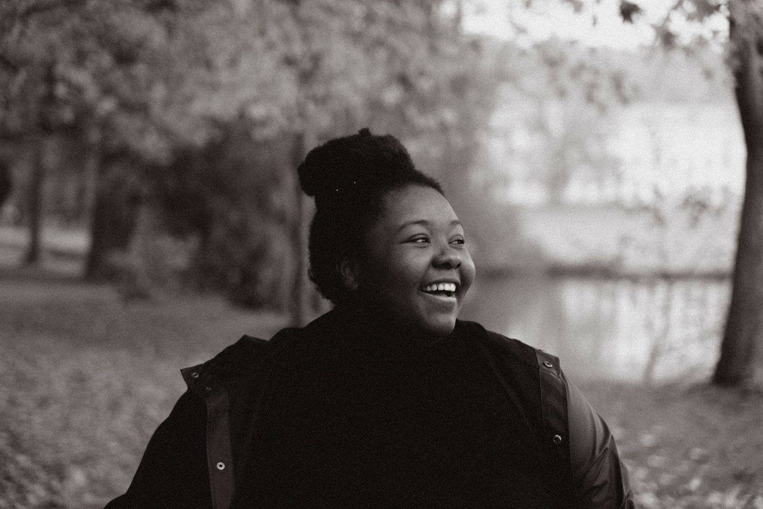 A candid black and white portrait capturing a joyful moment outdoors.