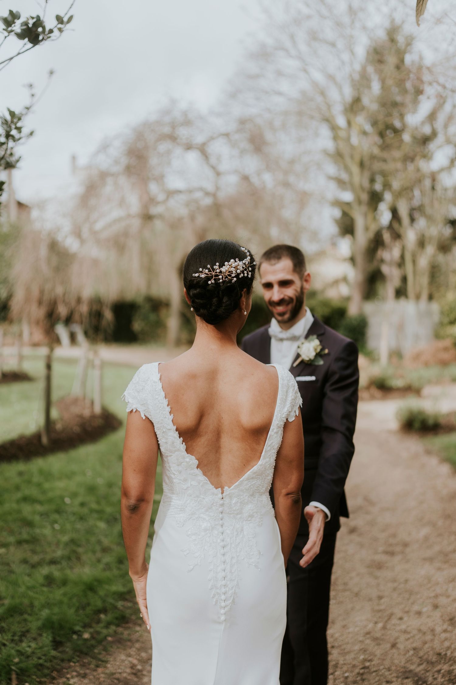 A romantic first look moment between newlyweds on a garden path.