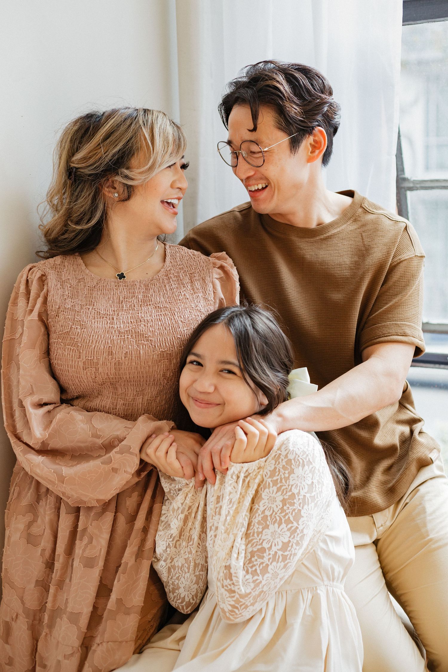 Loving family sharing joyful moment together against white wall.