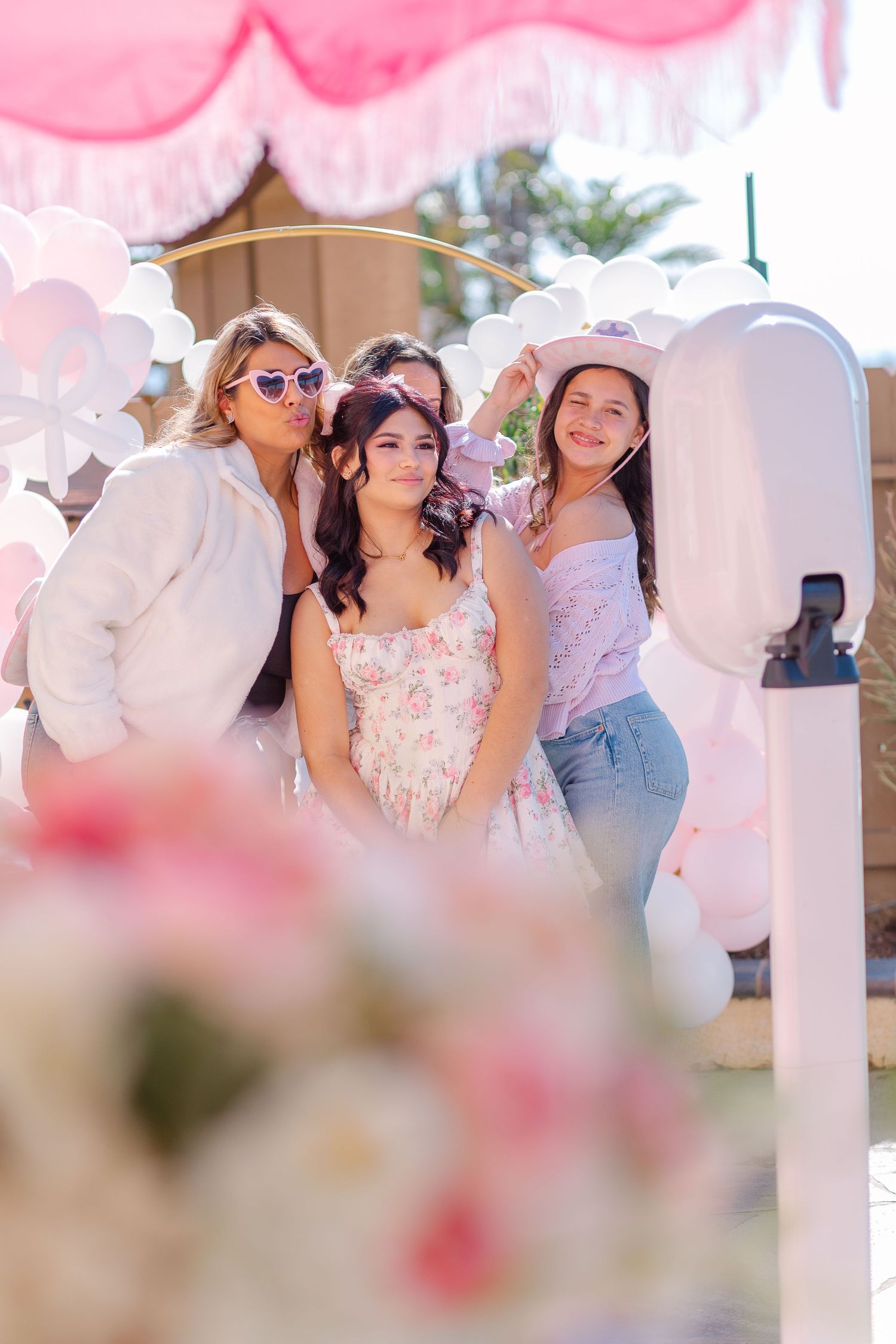 Festive party scene with pink balloons and decorations at an outdoor celebration.