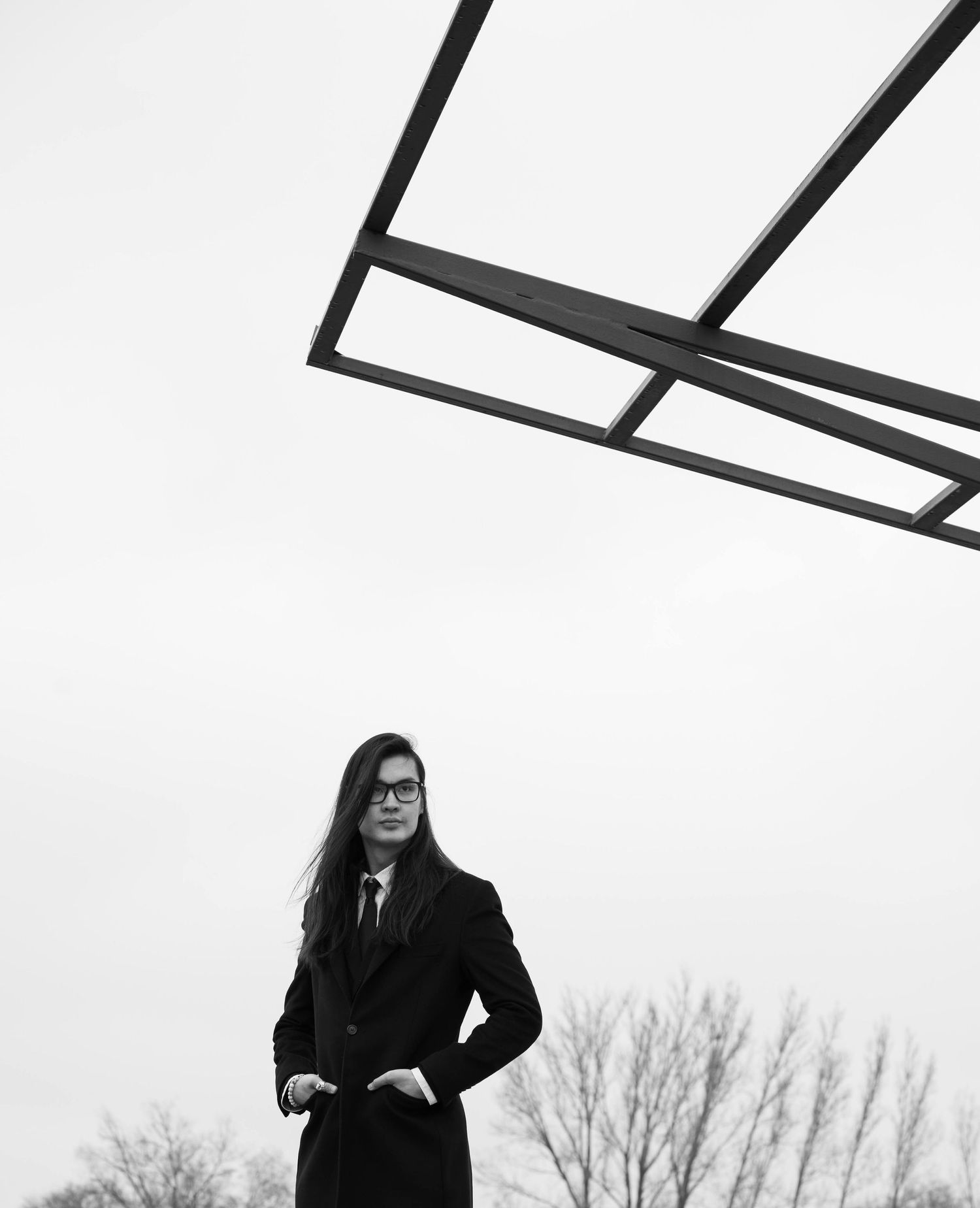 Black and white street portrait photography of an Asian man with long hair in Seattle