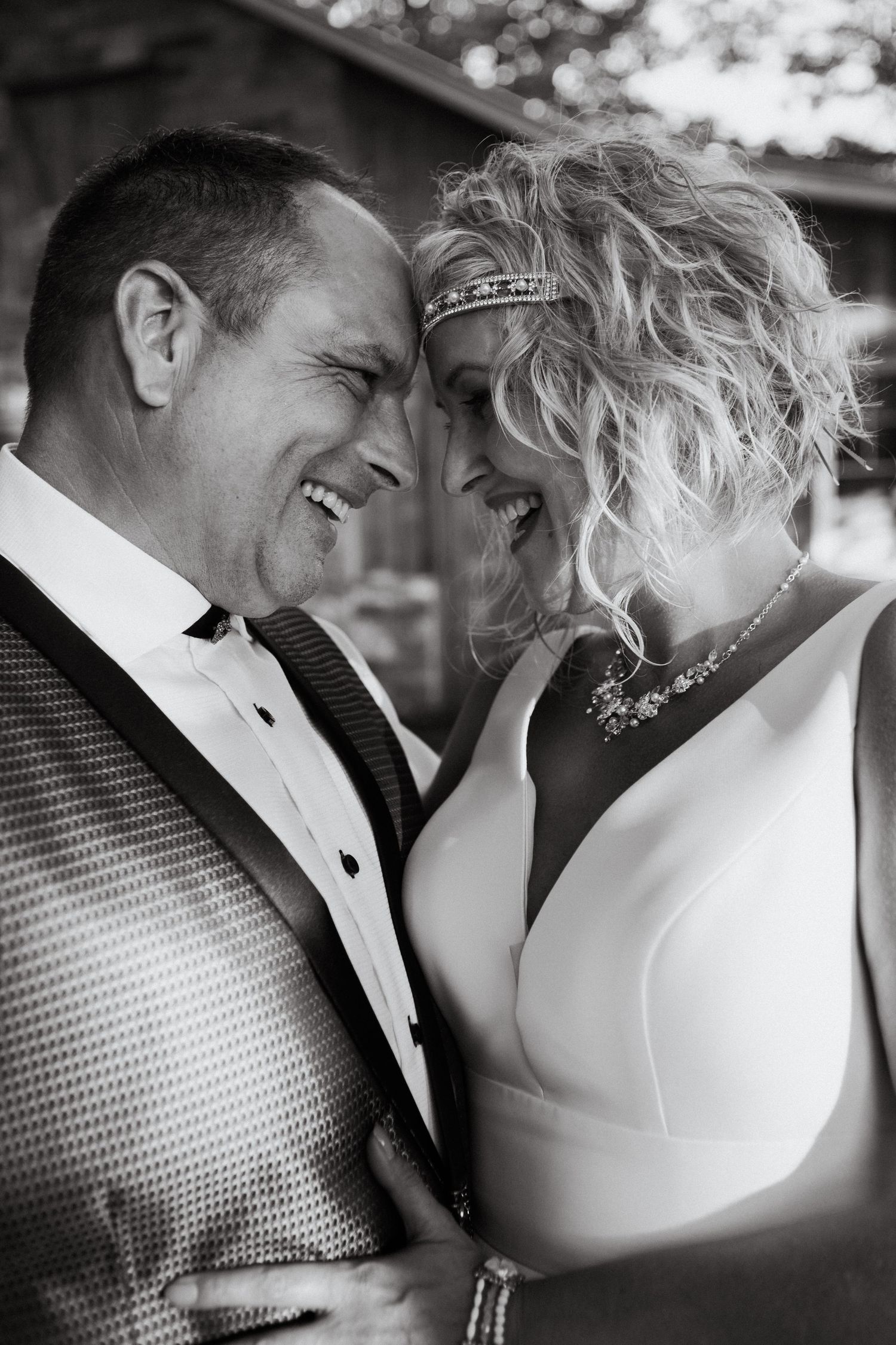 Black and white intimate portrait of newlyweds sharing a romantic moment.